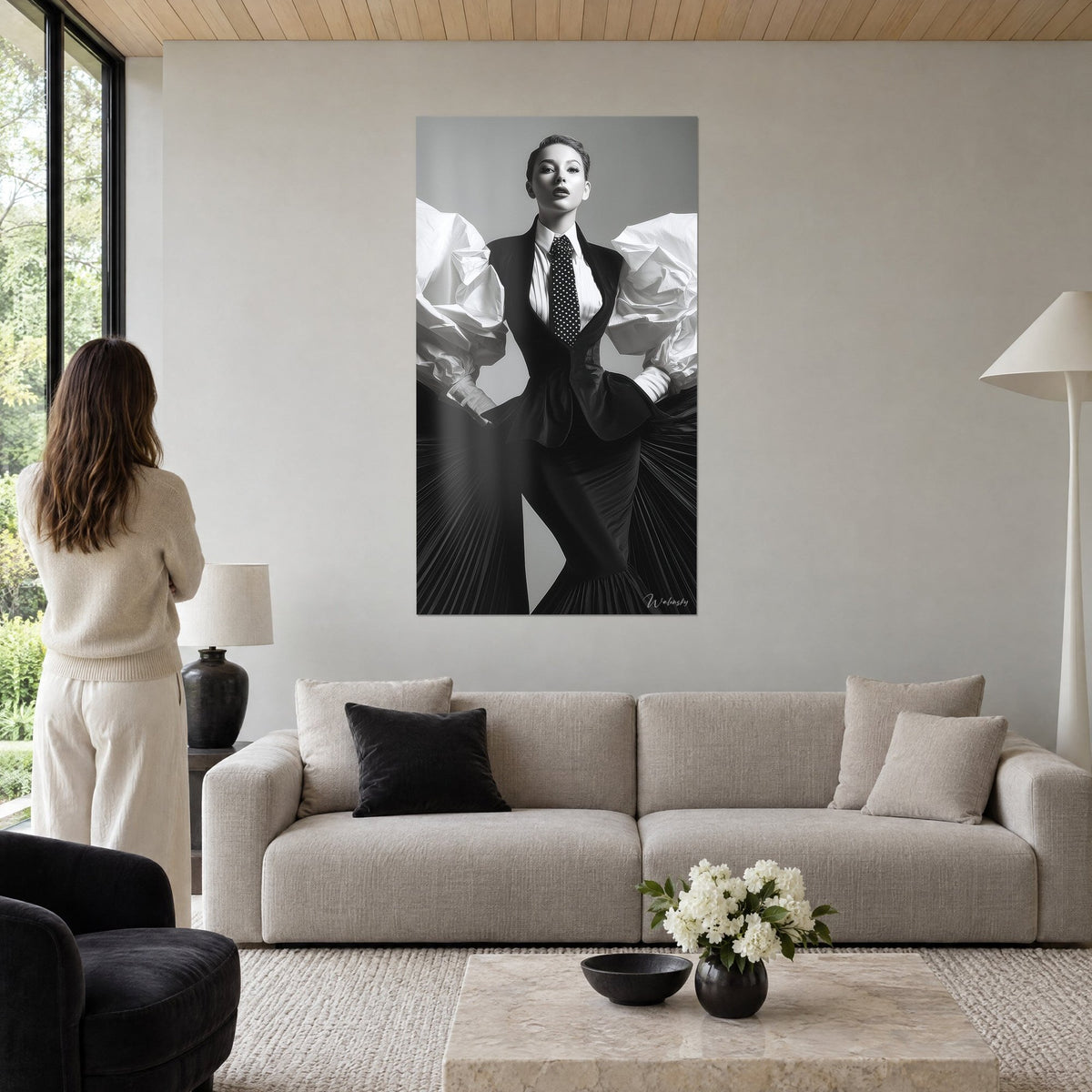 Tableau mannequin en gilet noir et cravate à pois, manches bouffantes blanches froissées, au-dessus d'un canapé dans un salon lumineux