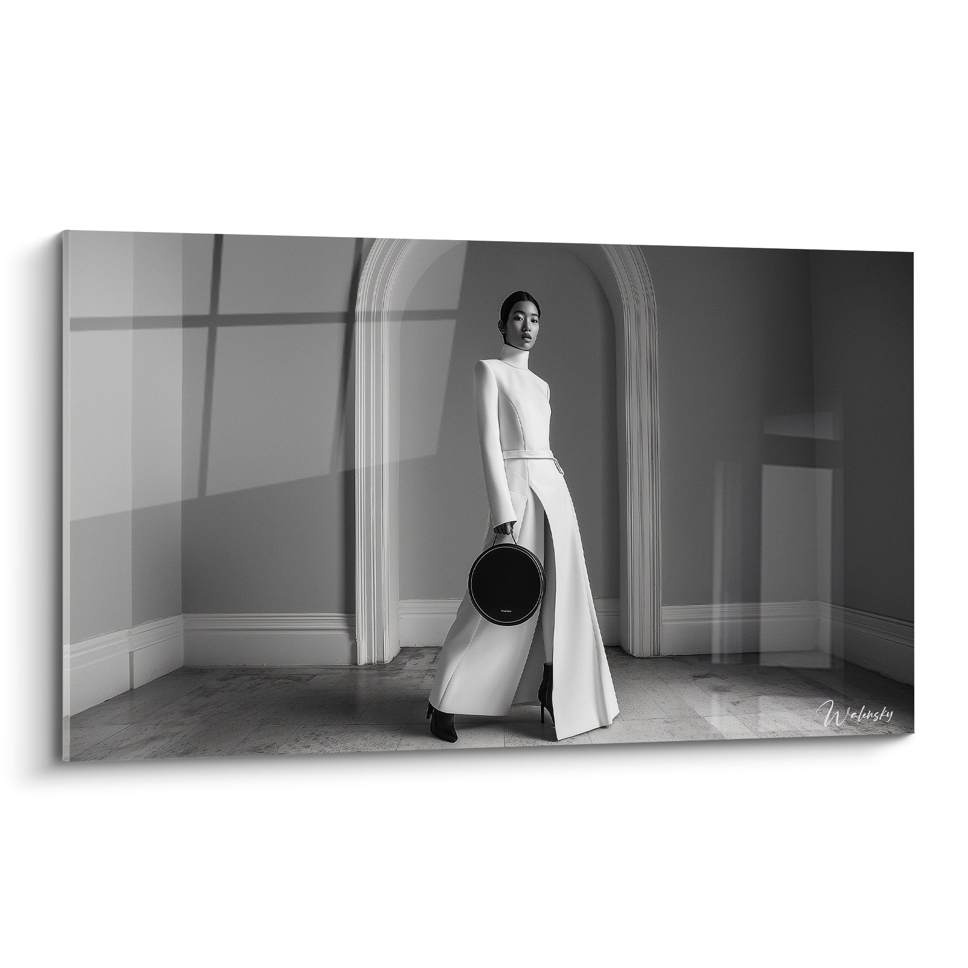 Mannequin en robe blanche fendue et sac noir, silhouette élancée sous une arche grise
