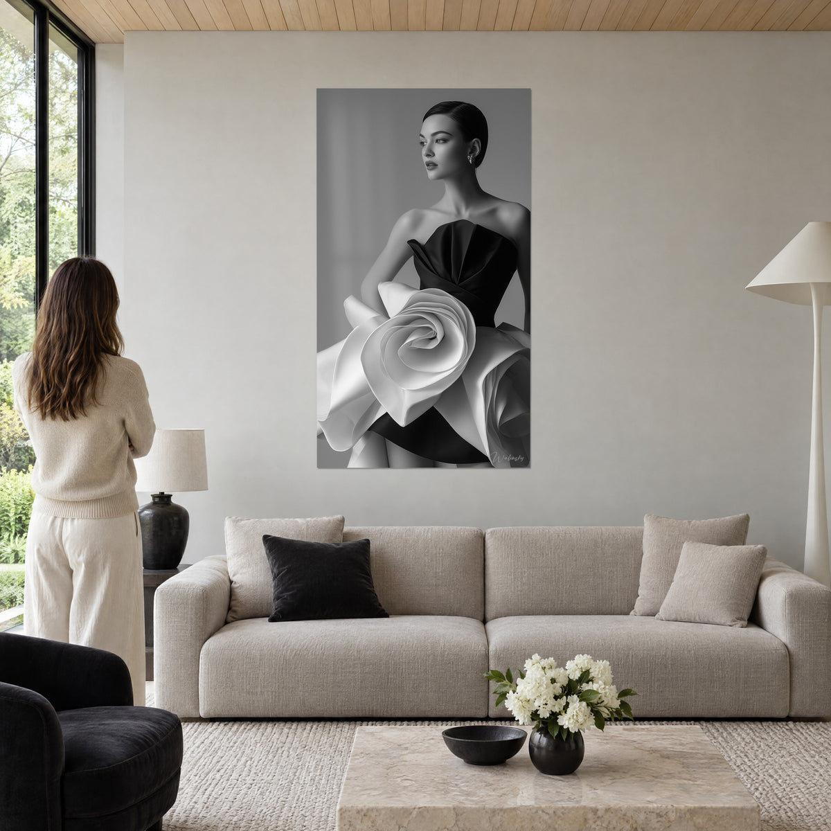 Schilderij mannequin met strakke knot en zwarte bustier, enorme witte satijnen roos op grijze achtergrond, boven een bank in een lichte woonkamer
