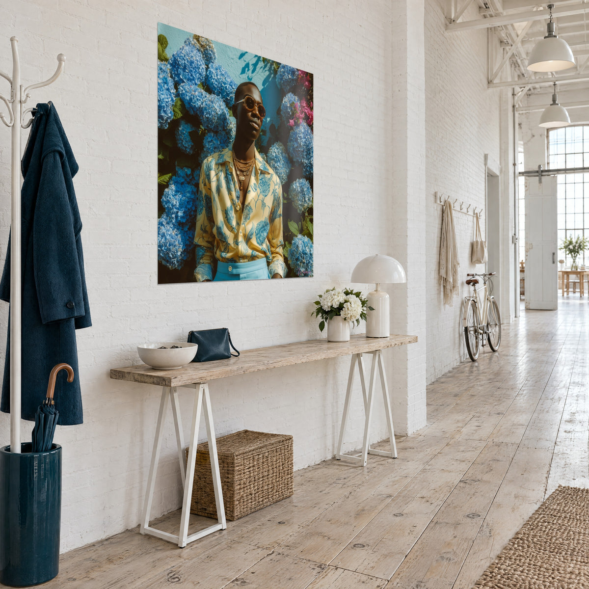Wall art portrait in a cream shirt printed with blue flowers, gold necklaces, turquoise wall, three-quarter view in a loft with light wood floors