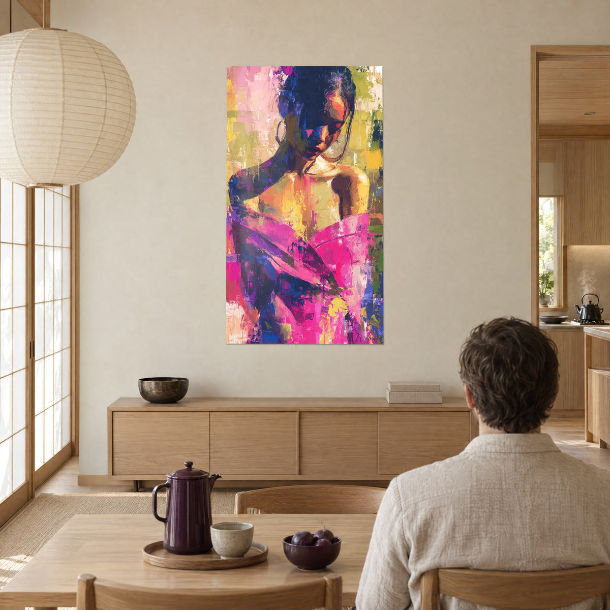 Tableau beauté abstraite, chignon sombre et peau orangée sous un drapé rose vif et indigo, face à un homme attablé près d'une baie vitrée