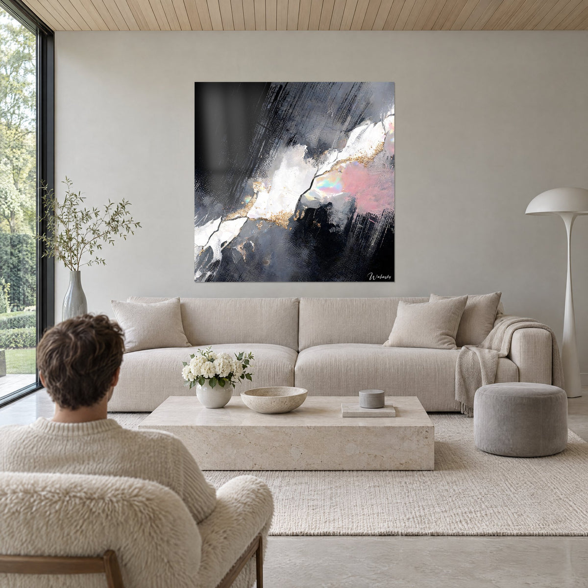 Tableau faille marbrée blanc nacré et anthracite, filets dorés, reflets rosés, au-dessus d'un canapé dans un salon lumineux