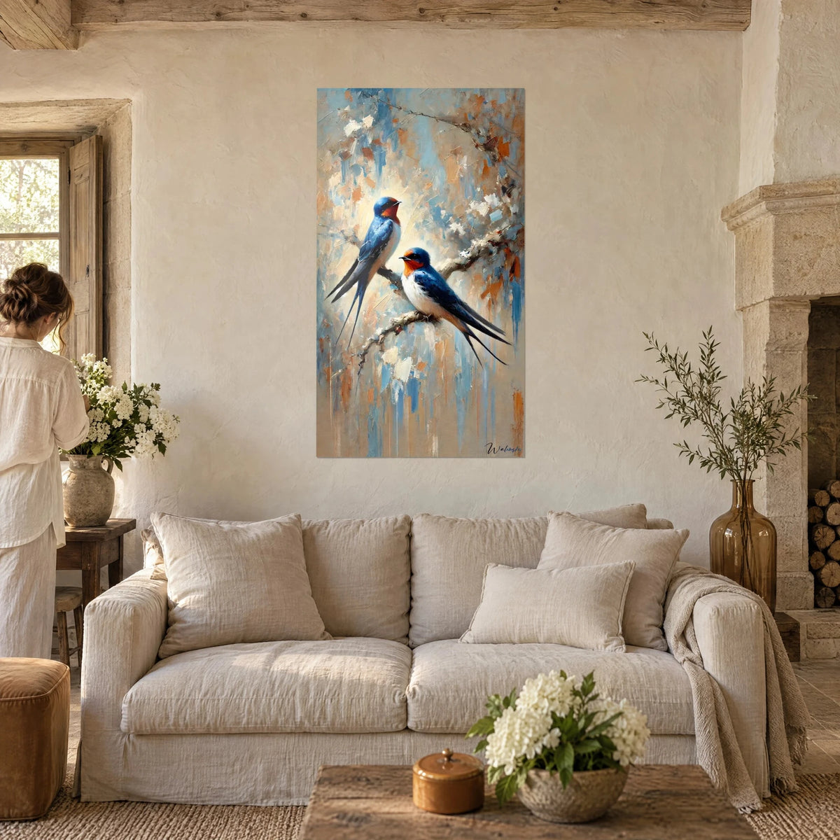 Quadro di rondini rustiche appollaiate su un ramo, petto bianco e dorso blu notte su fondo sabbia, sopra un divano in un soggiorno luminoso