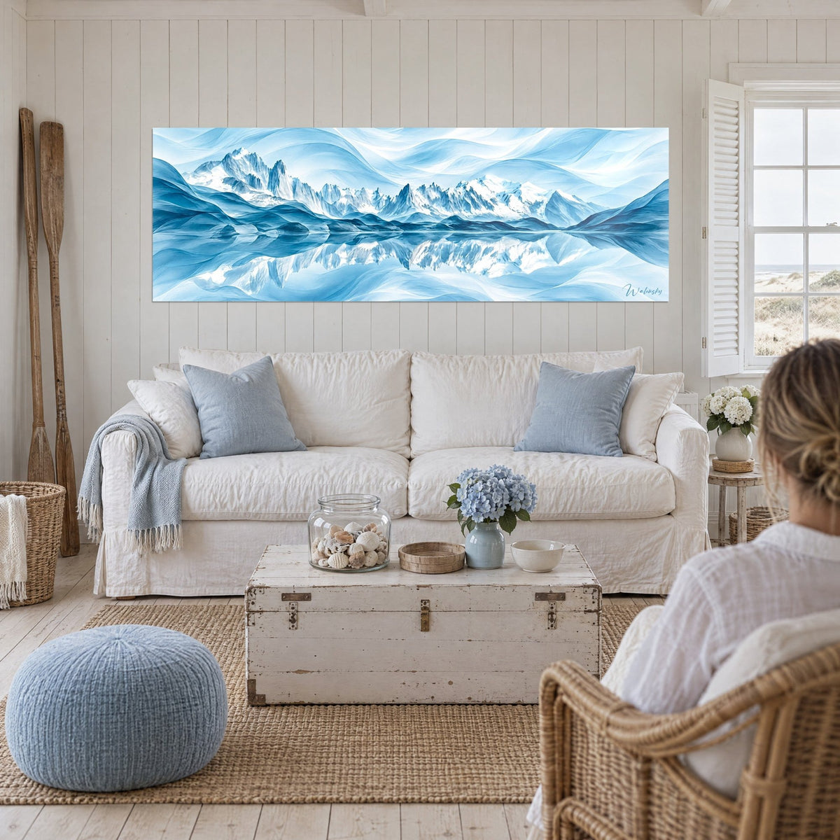 Gemälde massiver verschneiter Berg mit Wellenformen in Gletscherblau und Weiß, symmetrische Spiegelung im See, über einem Sofa in einem hellen Wohnzimmer