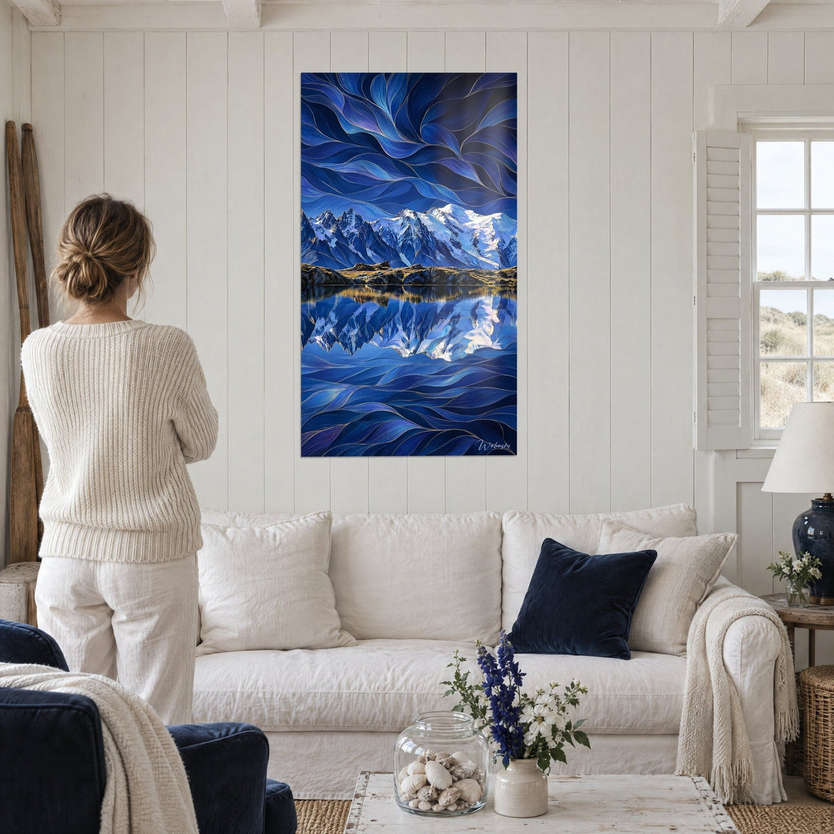 Wall art massive snowy mountain reflected in a lake, midnight blue and white, sky of rippling petals, above a sofa in a bright living room