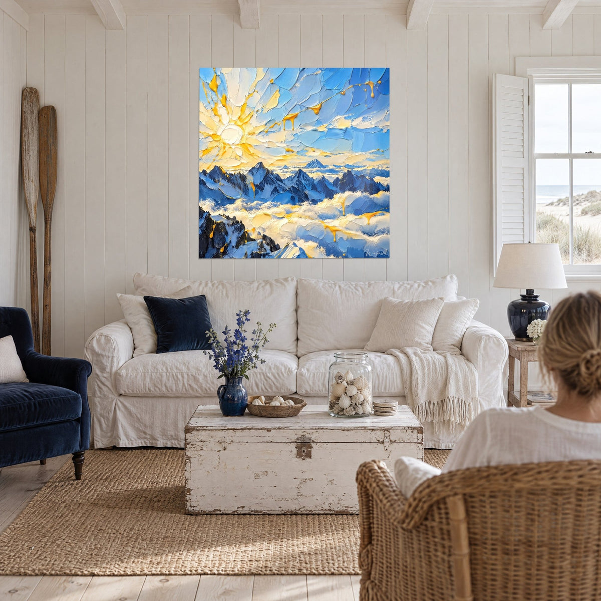 Wall art Snow-capped peaks in midnight blue beneath a golden, raised sun, yellow drips, above a sofa in a bright living room