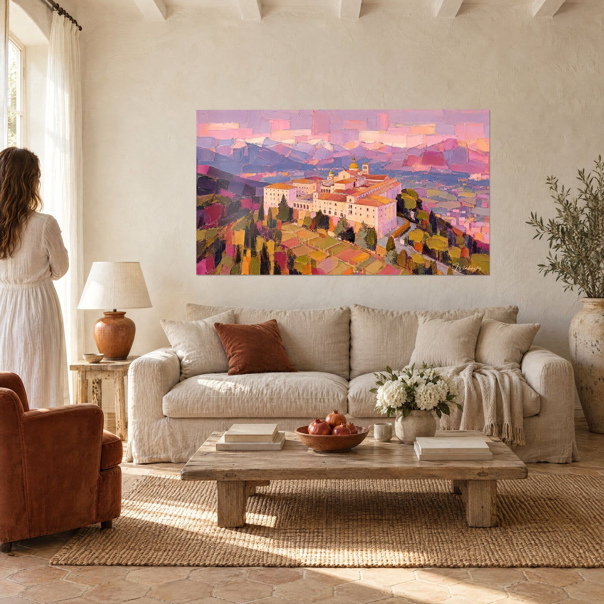 Tableau abbaye perchée aux murs rose pâle et dômes dorés sur collines violettes, au-dessus d'un canapé dans un salon lumineux