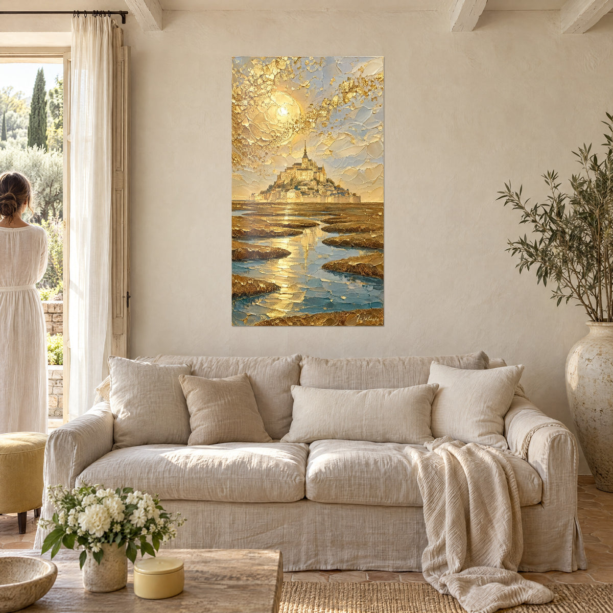 Quadro abbazia dorata sulla sua riva, cielo crema e pozzanghere azzurro turchese, una donna di spalle, sopra un divano in un soggiorno luminoso