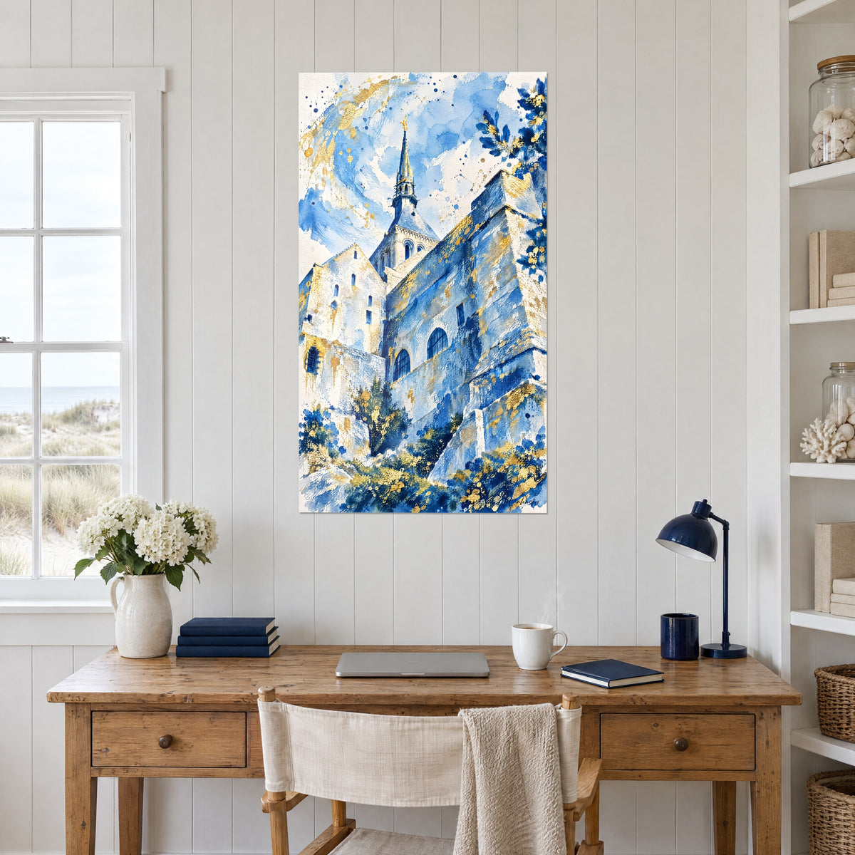 Schilderij Normandische vesting in blauw en goud, slanke torenspits en weelderig gebladerte, opgehangen boven een bureau van licht hout