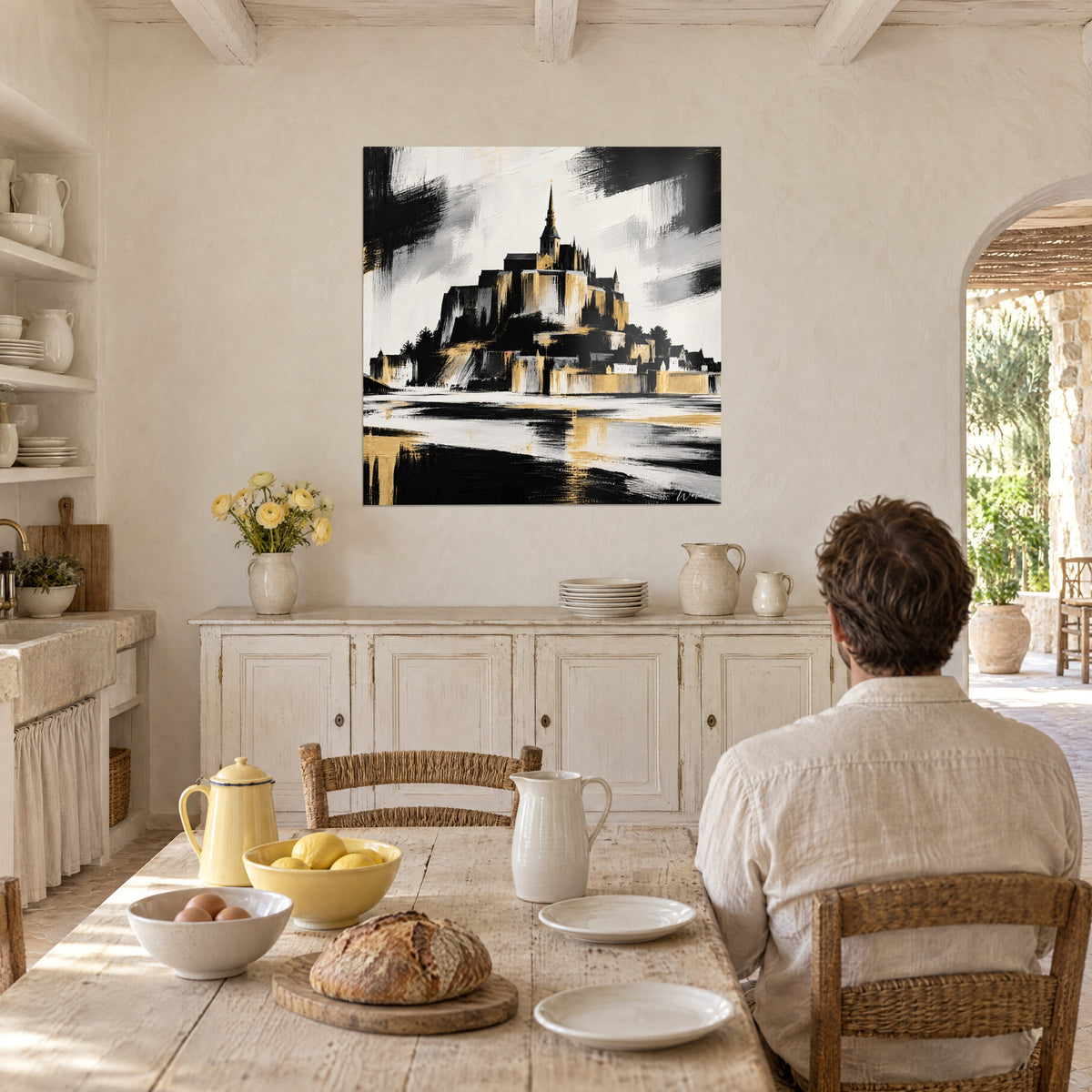 Schilderij donkere silhouet van de Mont-Saint-Michel, gouden glans en een witte lucht bekrast met zwart, boven een rustieke keukentafel