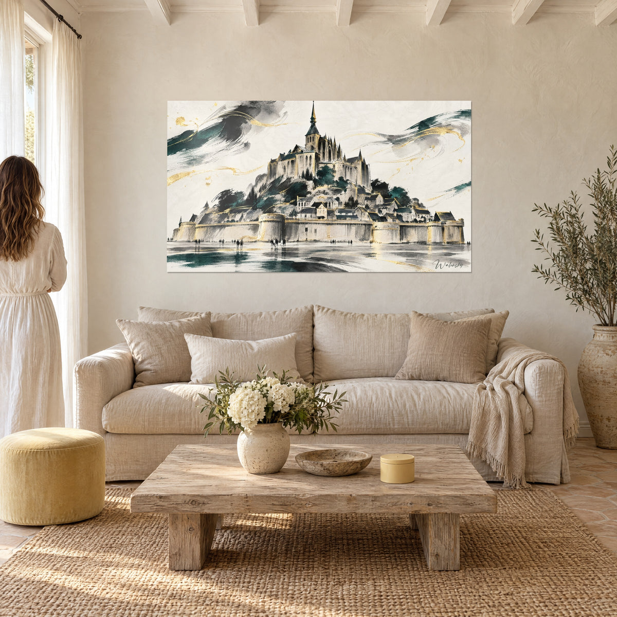 Gemälde Abtei auf ihrem Felsen in Gold, elfenbeinfarbene Festungsmauern und Aquarell in Petrolgrün, Frau von hinten, über einem Sofa in einem hellen Wohnzimmer