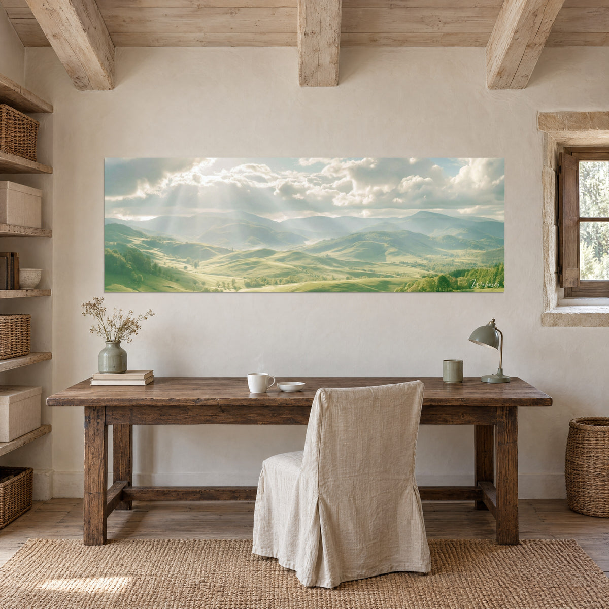 Tableau chaîne de collines vert sauge, ciel pastel traversé de faisceaux lumineux, accroché au-dessus d'une table de bureau en bois brut