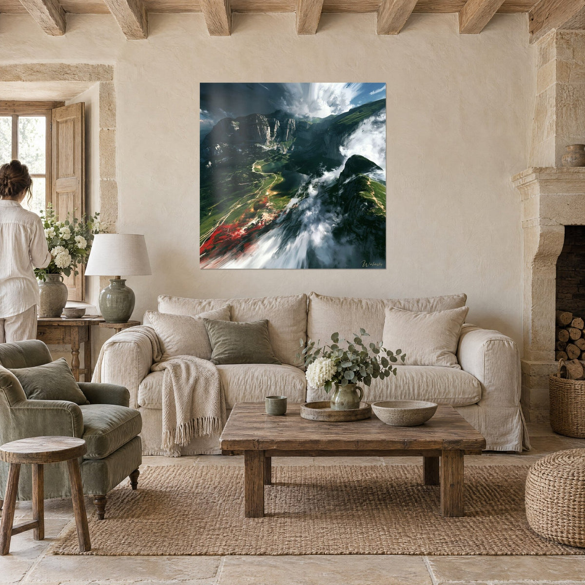 Tableau vallée alpine verte et lac sombre, coulées de nuages blancs et touches rouges, au-dessus d'un canapé dans un salon lumineux