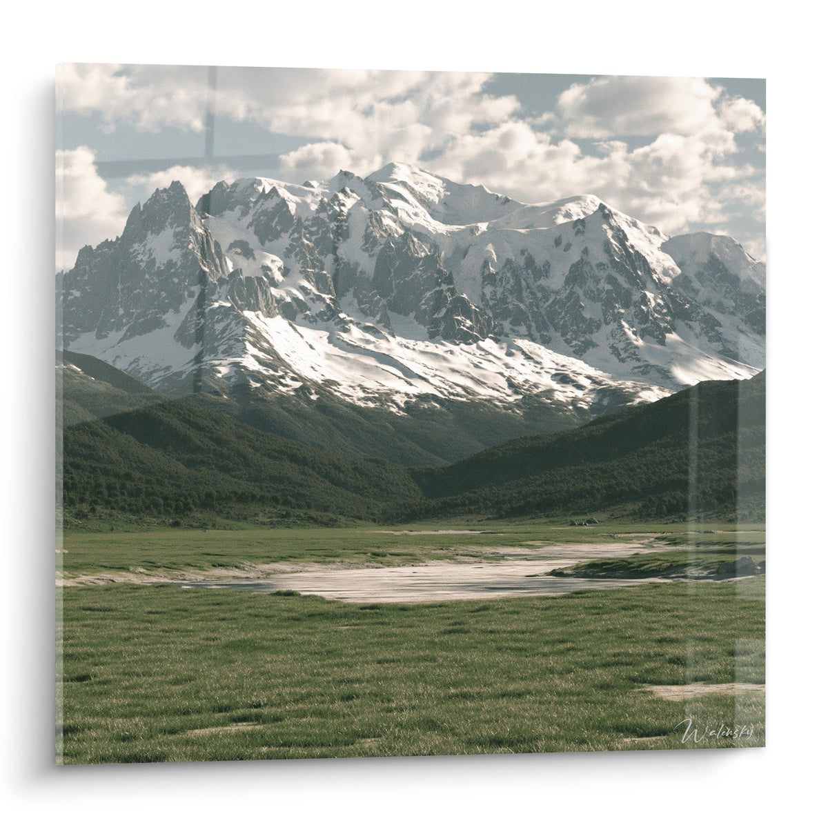 Massif montagneux enneigé aux teintes blanches et anthracite dominant une vallée verte