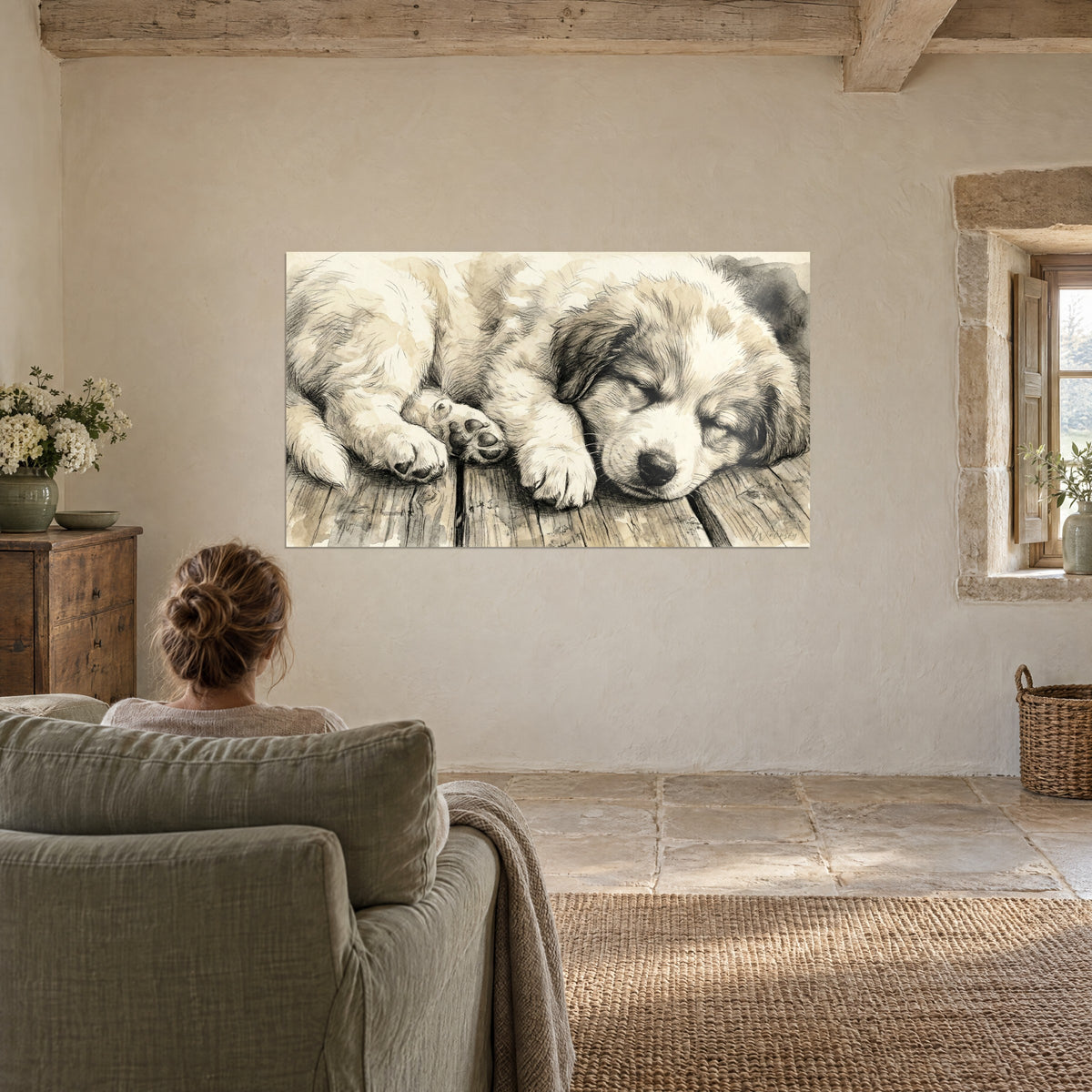 Wall art puppy curled up on weathered parquet, tucked paws, cream and brown tones, facing a woman seen from behind in a sage armchair