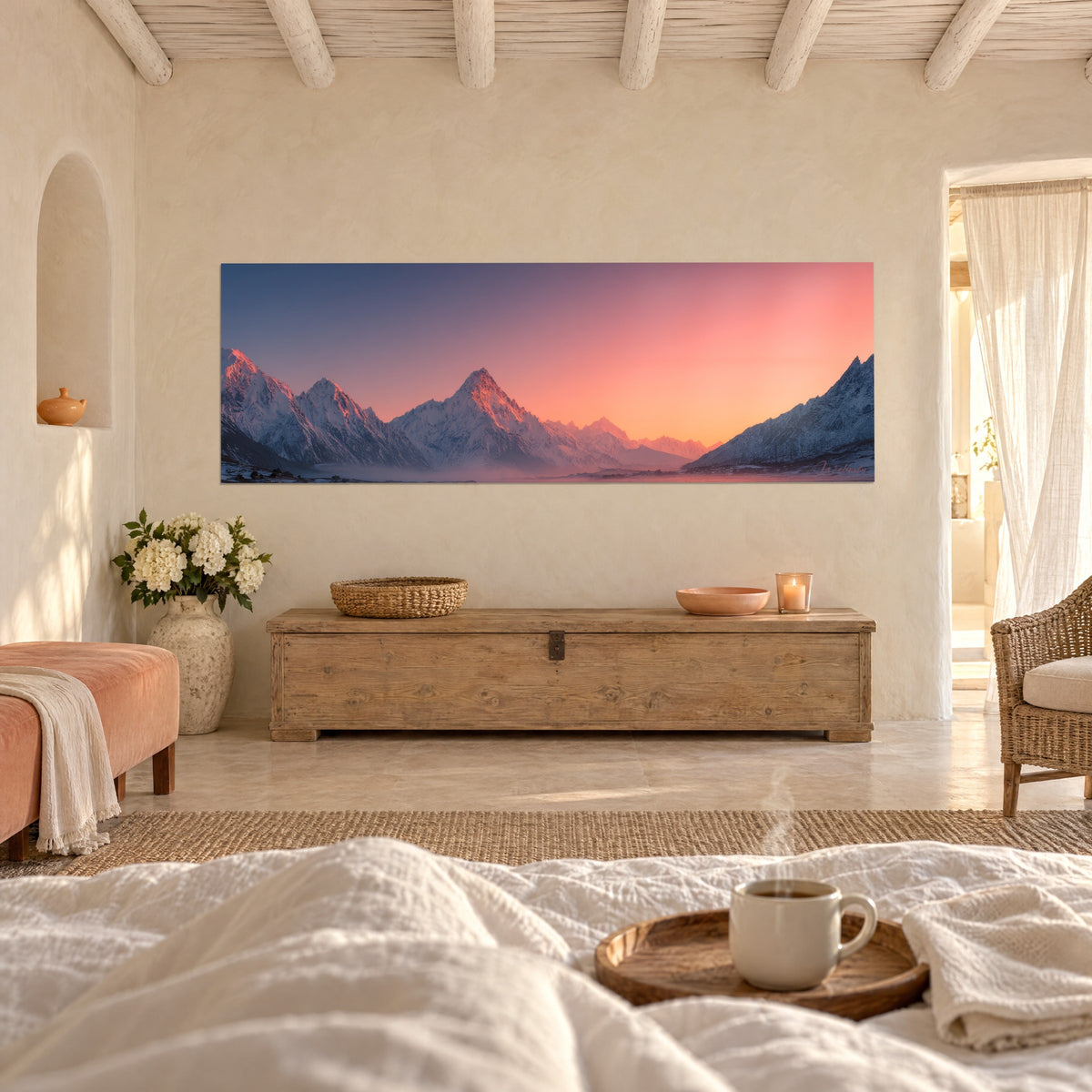 Cuadro pico nevado encendido en rosa y naranja sobre cielo índigo, encima de una cama en un dormitorio luminoso