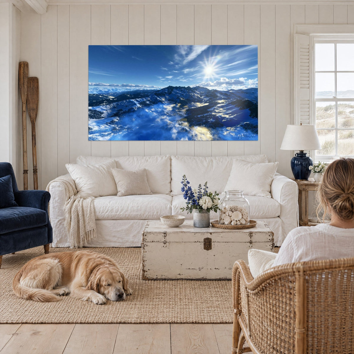 Tableau sommets enneigés sous un soleil étoilé, ciel bleu et neige blanche, au-dessus d'un canapé dans un salon lumineux