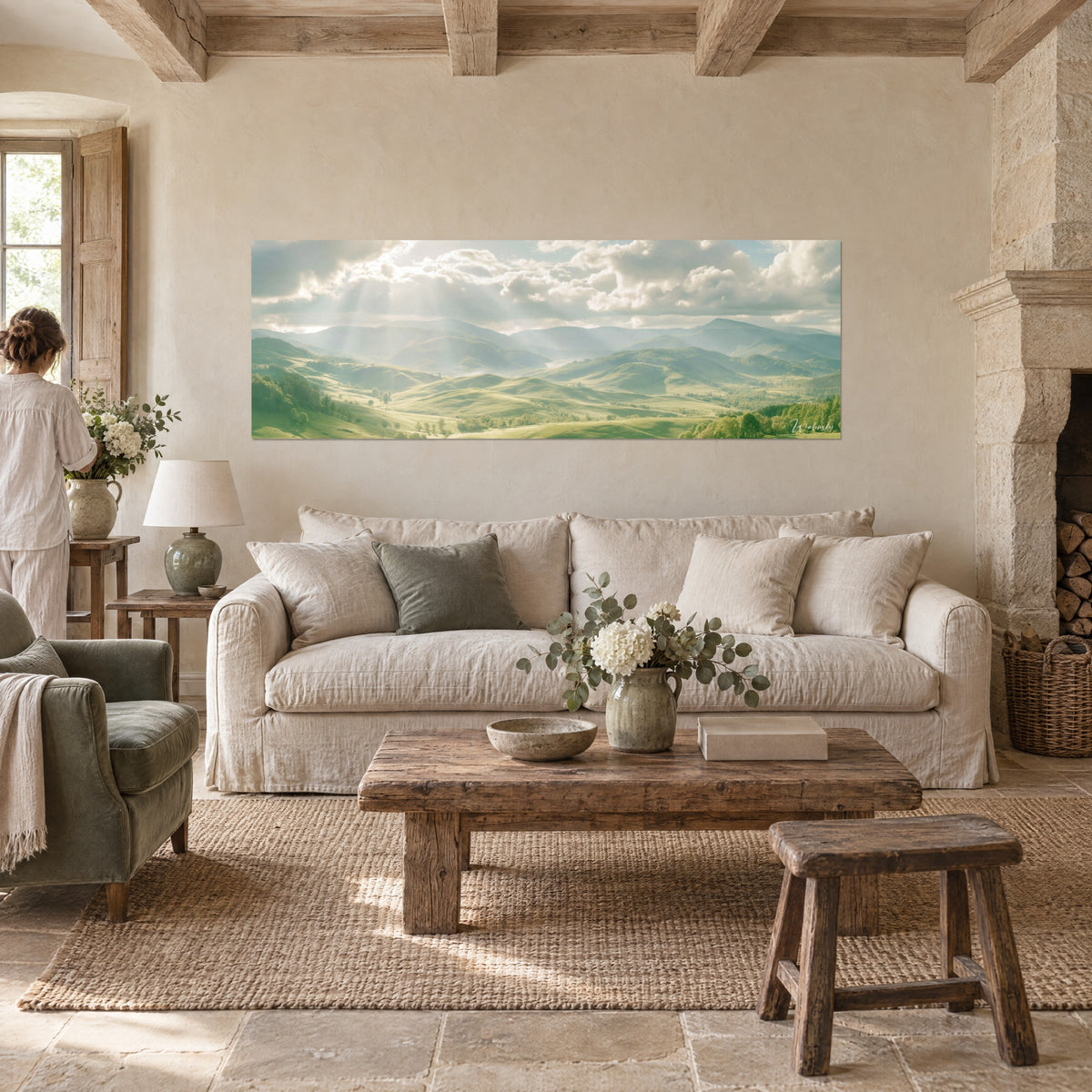 Tableau collines vertes baignées de rayons dorés, nuages blancs et lointains bleutés, au-dessus d'un canapé dans un salon lumineux
