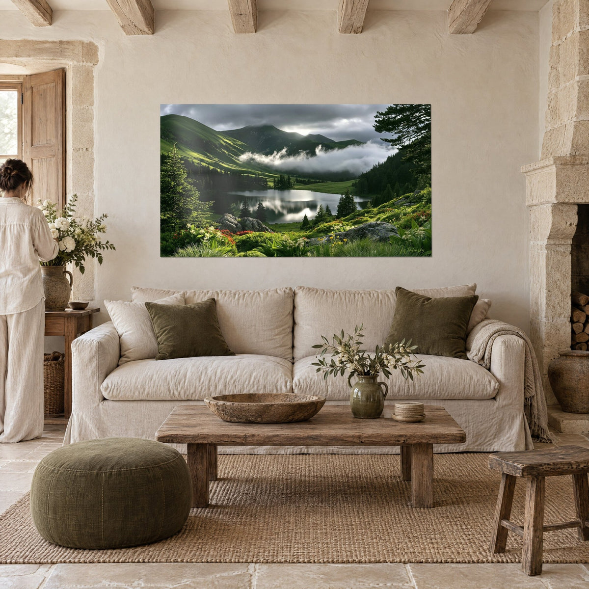 Tableau lac de montagne cerné de sapins sombres, brumes blanches et prairie verte, au-dessus d'un canapé dans un salon lumineux