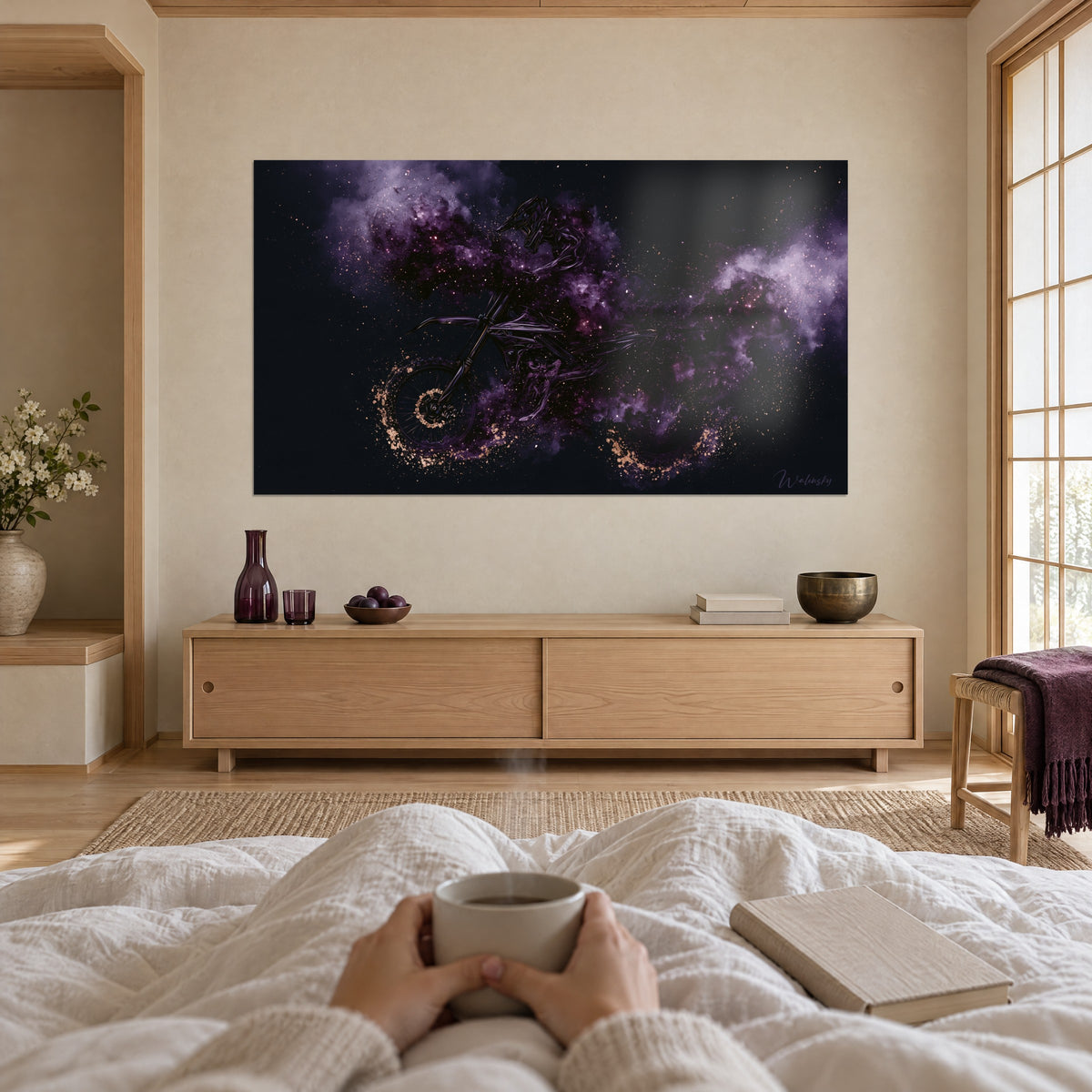 Wall art motocross rider in mauve smoke and copper sparkles against a black night, white bed, mug in hands, above a bed in a bright bedroom