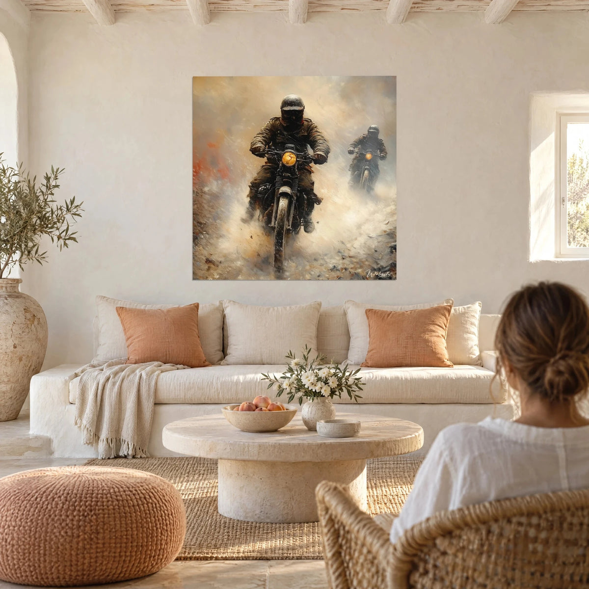 Tableau duo de motards casqués fonçant dans un nuage de poussière ocre et beige, phare jaune, au-dessus d'un canapé dans un salon lumineux