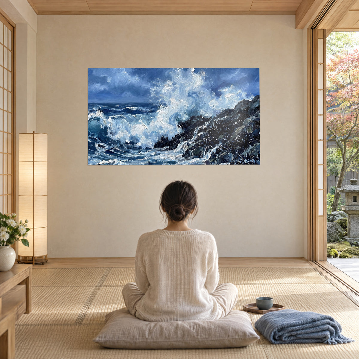 Tableau embruns tourbillonnants sur récif sombre, bleu cobalt et blanc nacré, face à une femme assise en tailleur, baie vitrée sur jardin