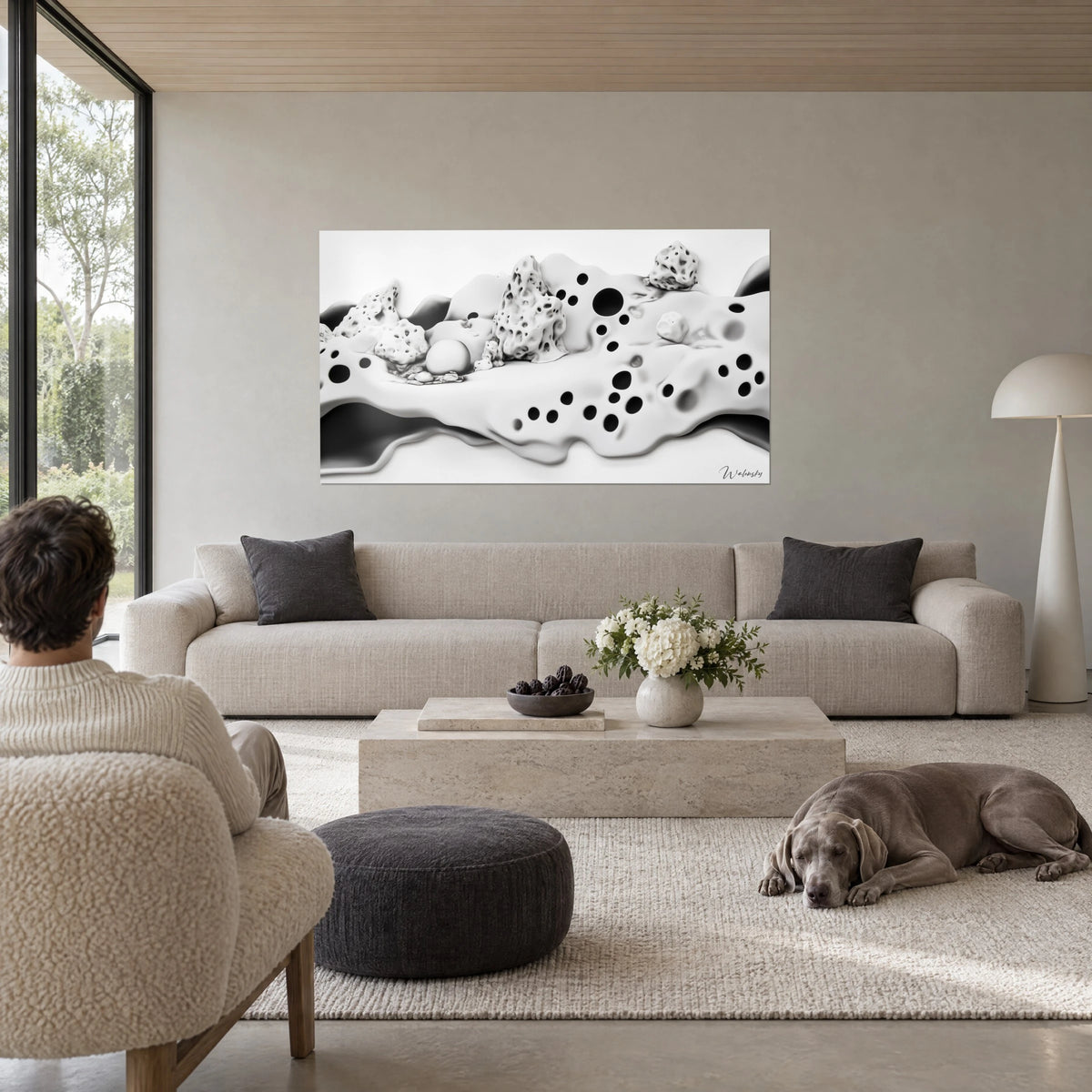 Cuadro paisaje de rocas alveoladas y dunas blancas salpicadas de agujeros negros, Weimaraner gris sobre un sofá en un salón luminoso