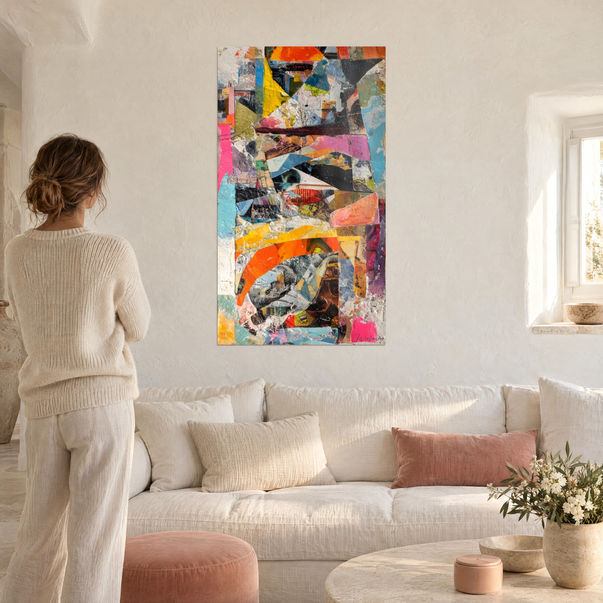 Cuadro collage de papeles rasgados en naranja vivo, fucsia y azul turquesa, mujer de espaldas, encima de un sofá en un salón luminoso