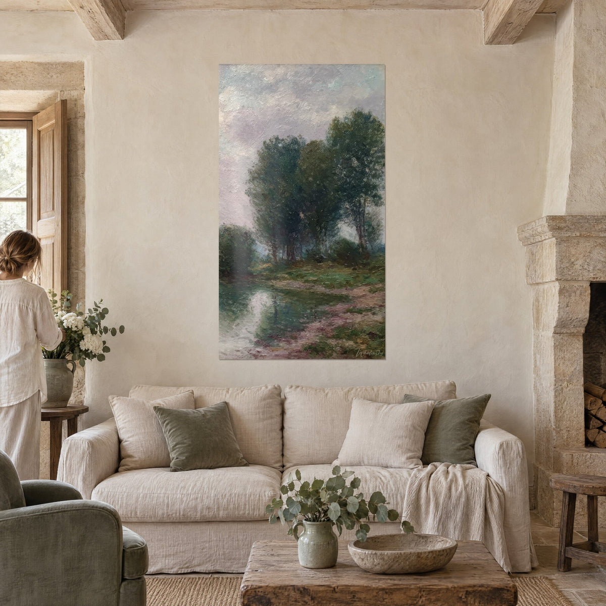 Tableau berge paisible, grands arbres verts et ciel mauve, une femme de dos, au-dessus d'un canapé dans un salon lumineux