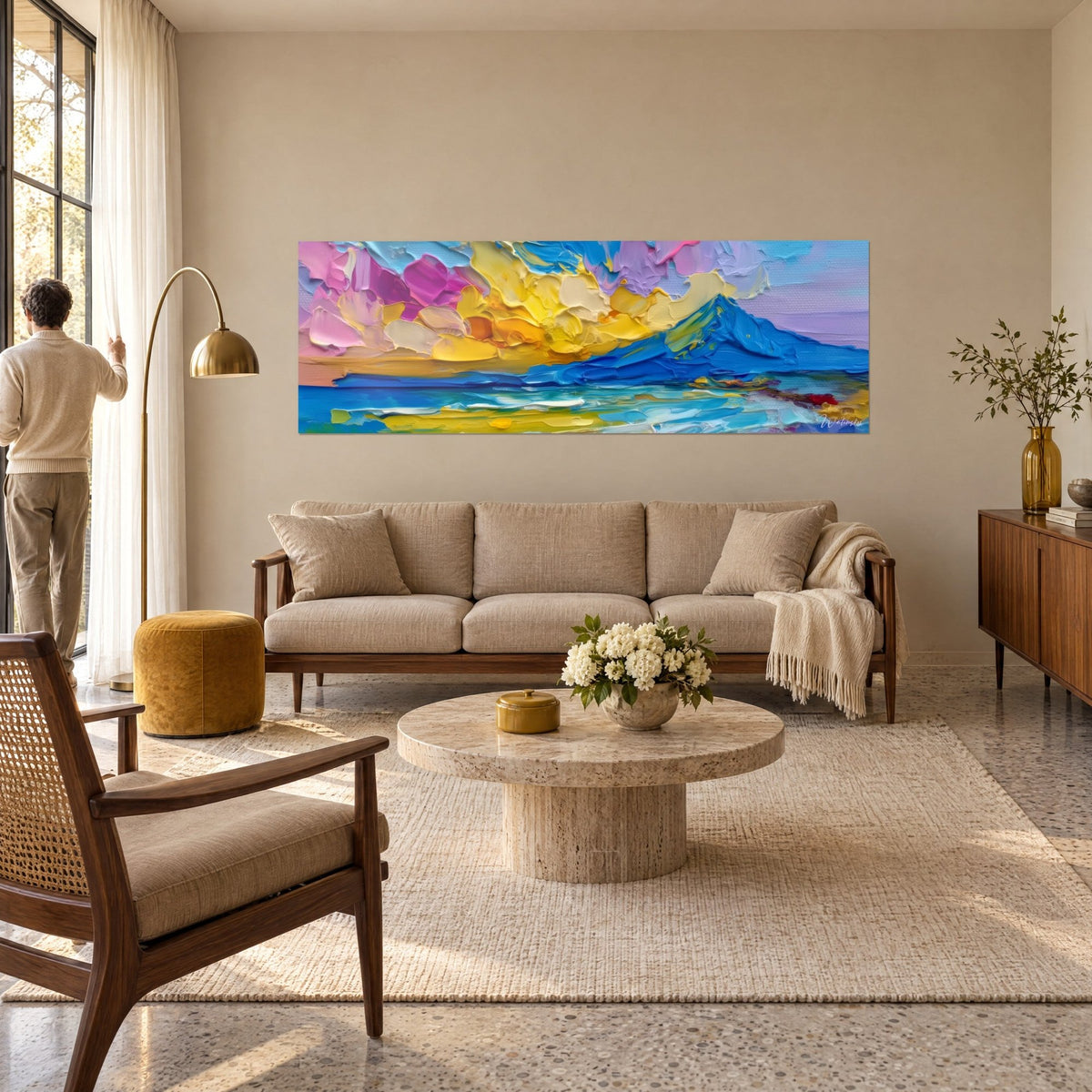 Cuadro cono volcánico en azul cobalto bajo nubes amarillo mantequilla y rosa, empastes con espátula, sobre un sofá en un salón luminoso