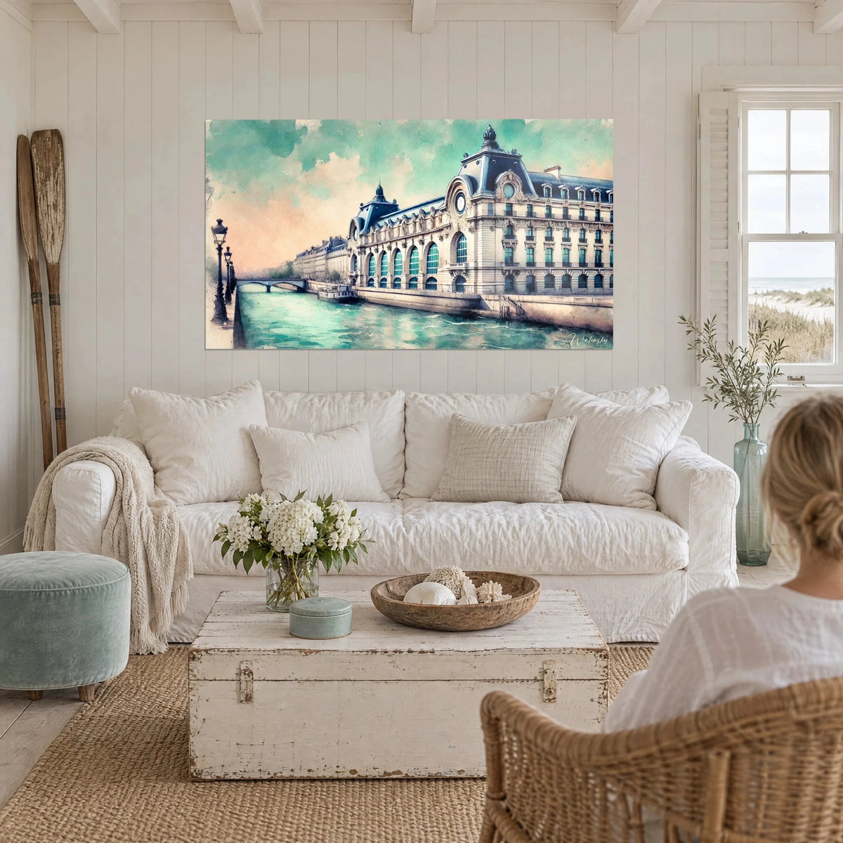 Tableau Musée d'Orsay en aquarelle, façade de pierre crème, ciel vert d'eau et rose, au-dessus d'un canapé dans un salon lumineux
