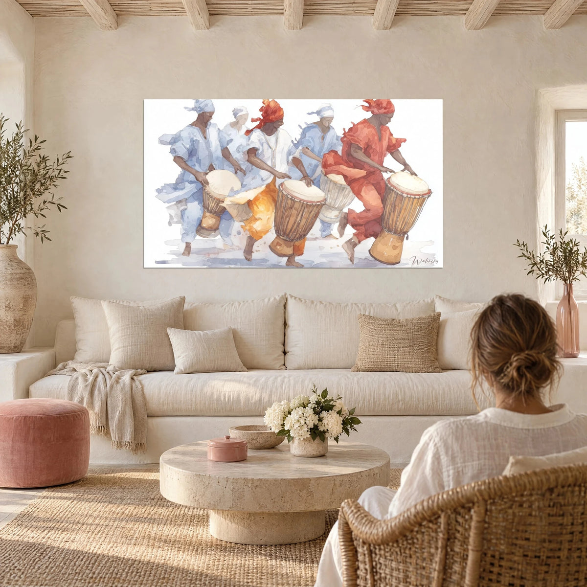 Schilderij Percussionisten in lichtblauwe en koraalrode gewaden die djembé spelen, boven een bank in een lichte woonkamer