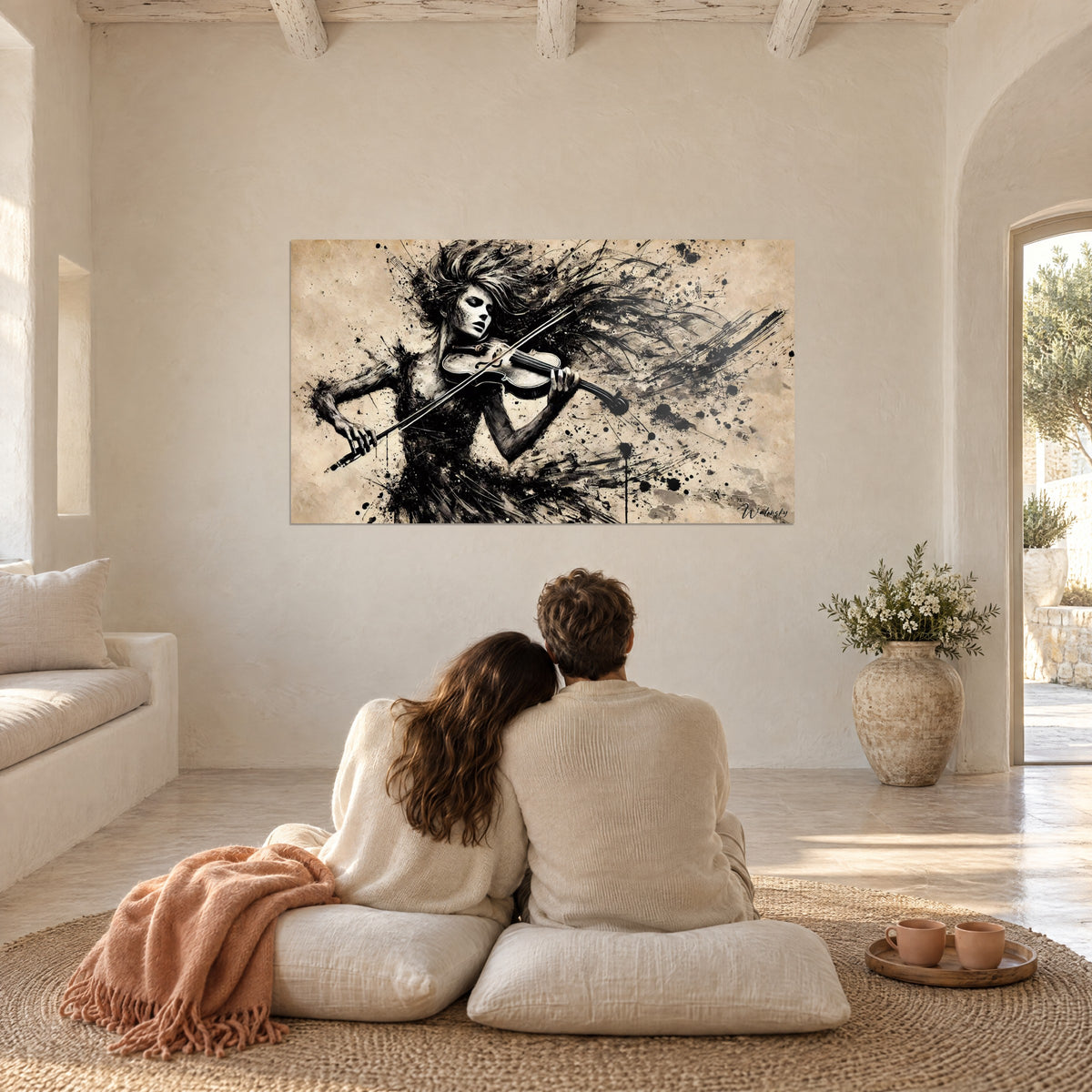 Quadro violino vibrante in gocce di inchiostro nero su fondo beige crema, di fronte a una coppia abbracciata su cuscini avorio