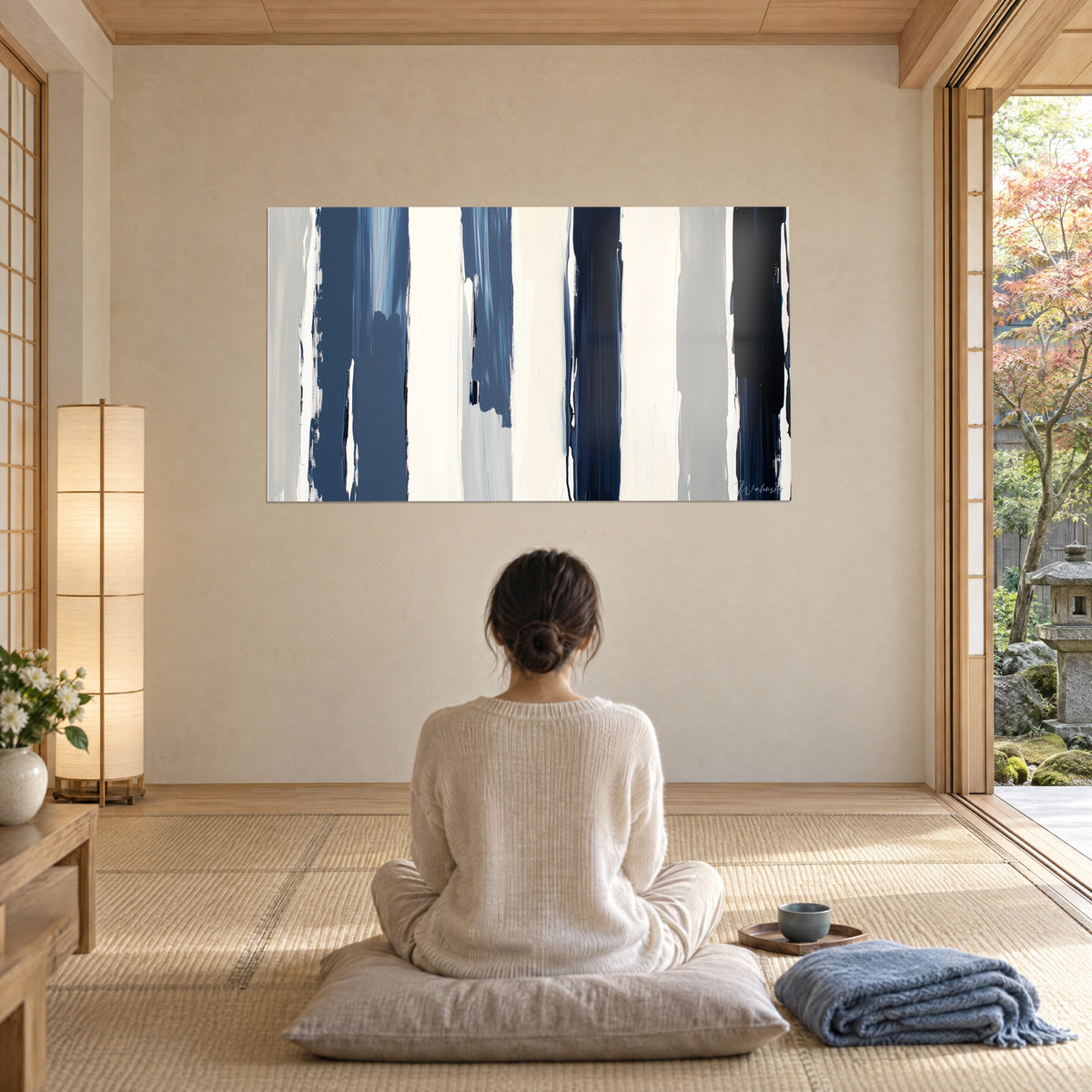 Wall art mural rhythmed with bands of blue-black and ivory, raised paint textures, admired by a woman seen from behind on a cushion