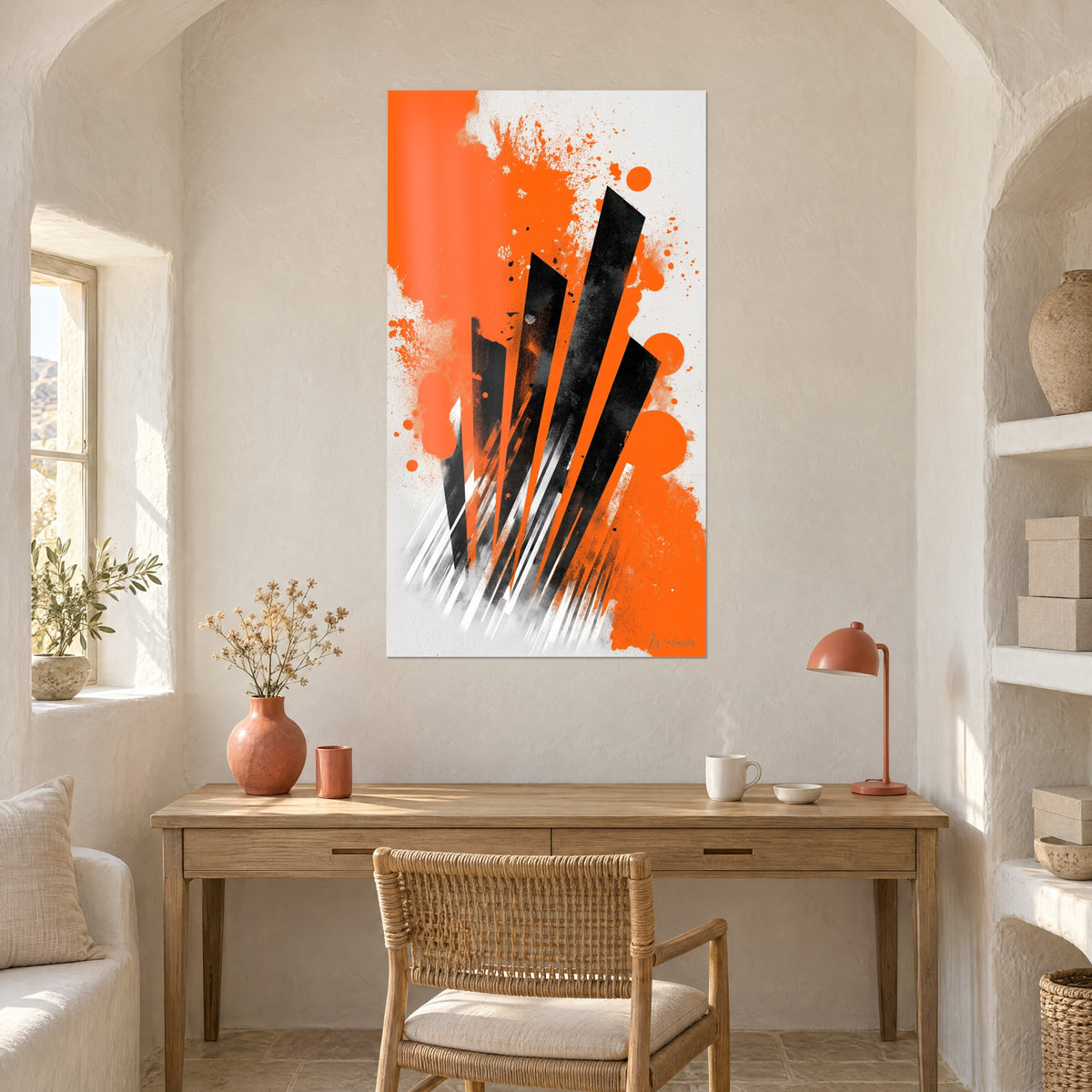 Wall art with bold black and orange strokes on a light background, hung above a wooden desk in a whitewashed room