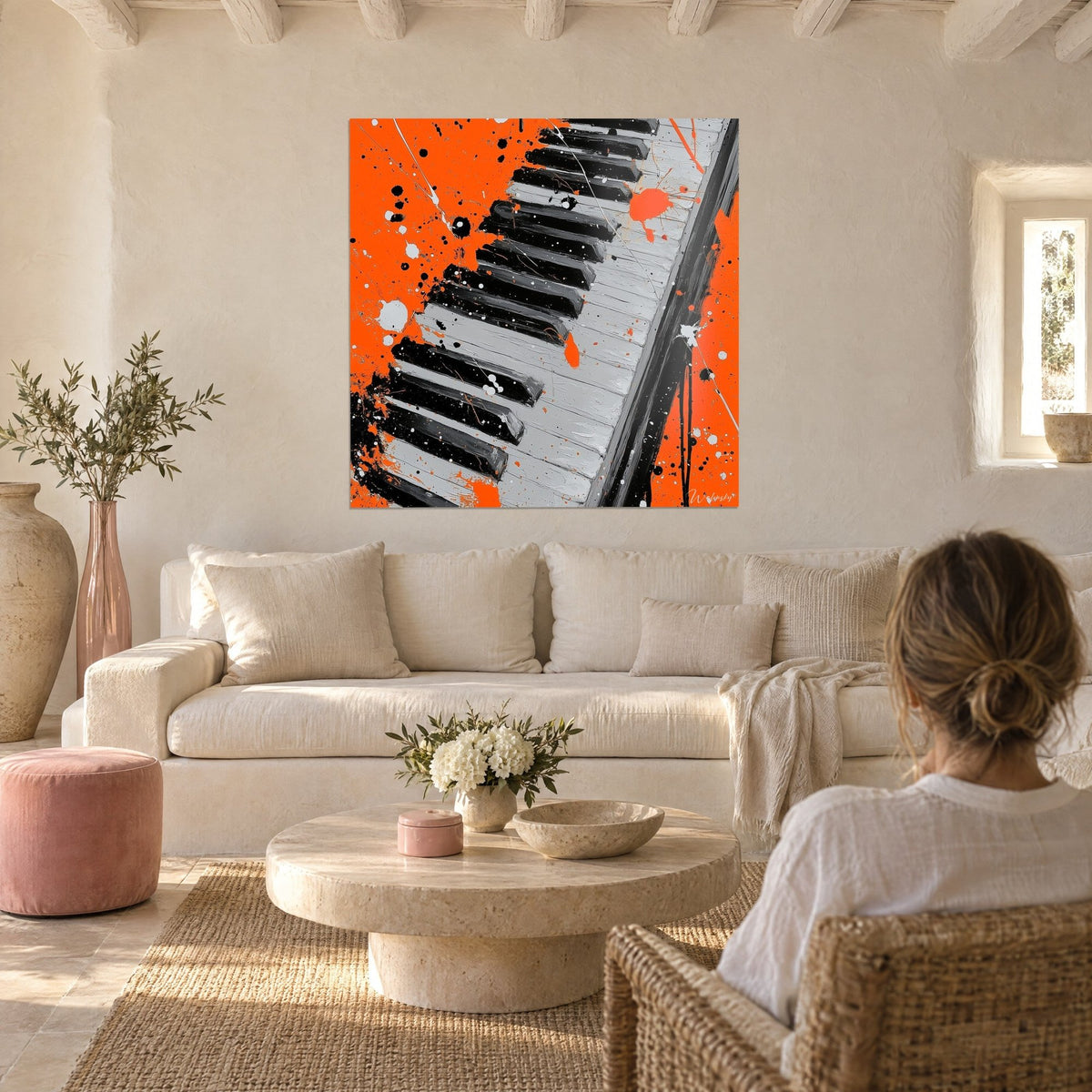 Tableau clavier de piano orange vif et noir, touches grises éclaboussées de peinture, au-dessus d'un canapé dans un salon lumineux