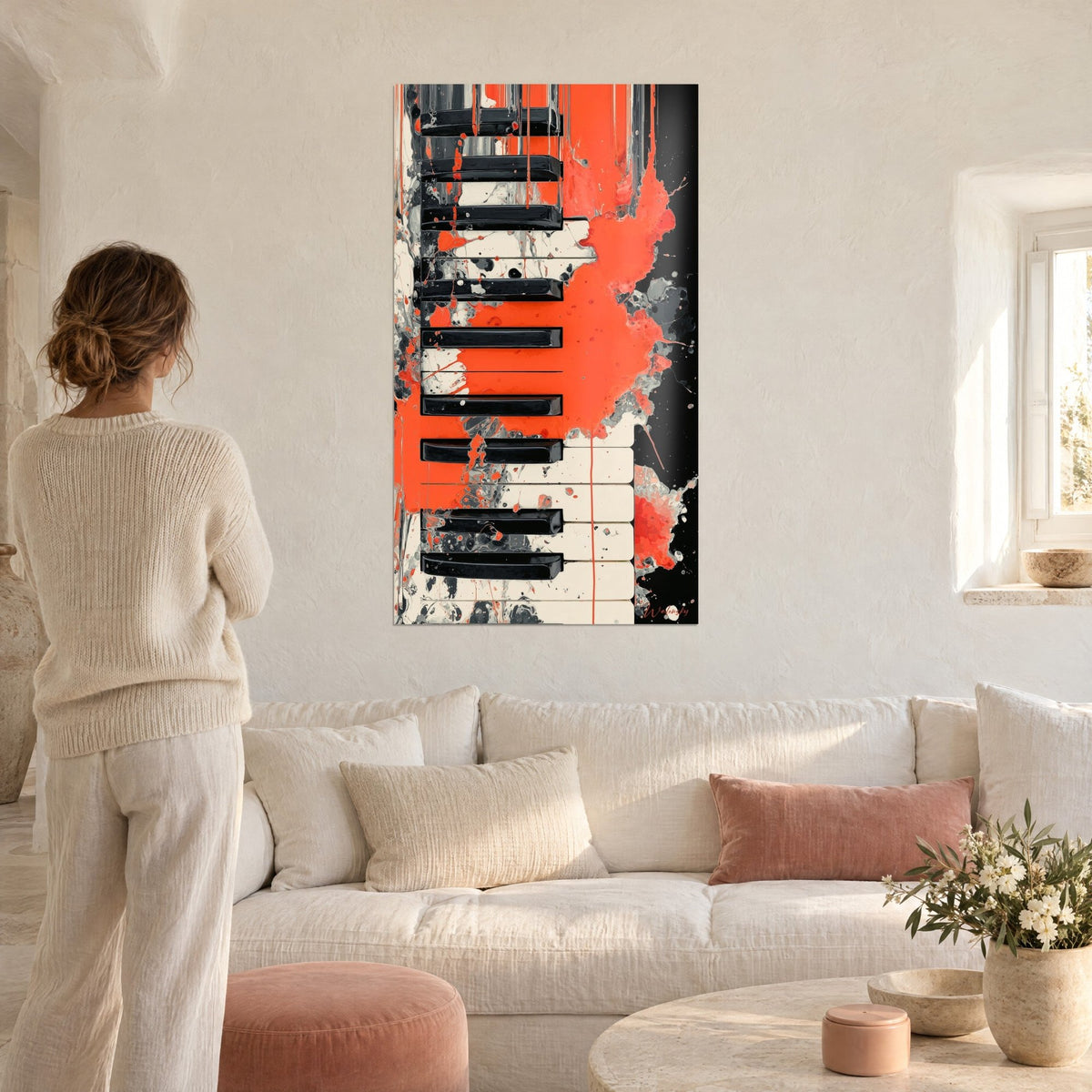 Gemälde Klaviertasten, lebhaft orange bespritzt, schwarze und elfenbeinfarbene Tasten, graue Laufspuren, über einem Sofa in einem hellen Wohnzimmer