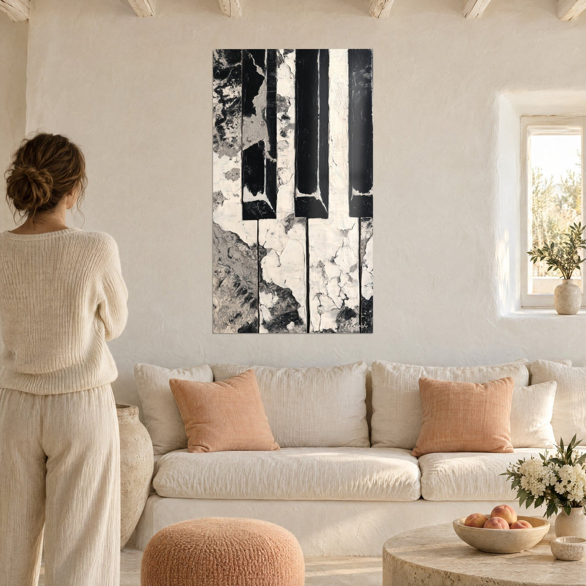Tableau clavier de piano aux touches ébène et ivoire écaillées, femme de dos, au-dessus d'un canapé dans un salon lumineux