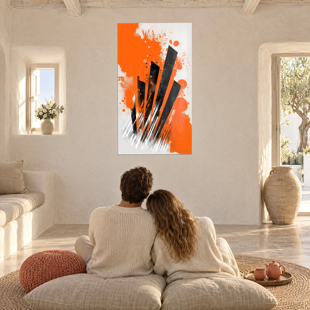 Wall art with bright orange splatters and black blades, couple seen from behind on cushions in a Mediterranean living room