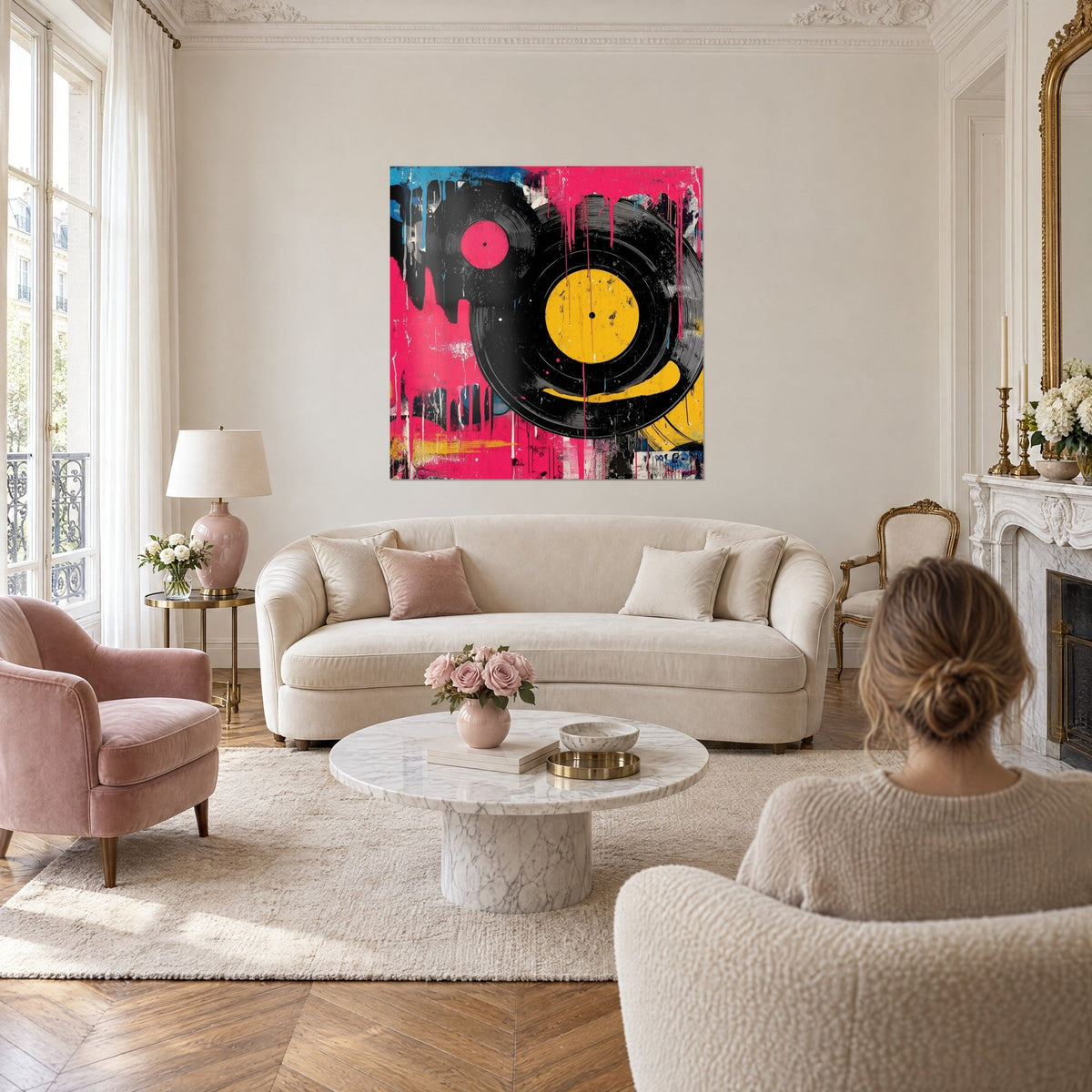 Cuadro discos de vinilo negros sobre fondo rosa fucsia, centro amarillo sol, goteos de pintura, sobre un sofá en un salón luminoso