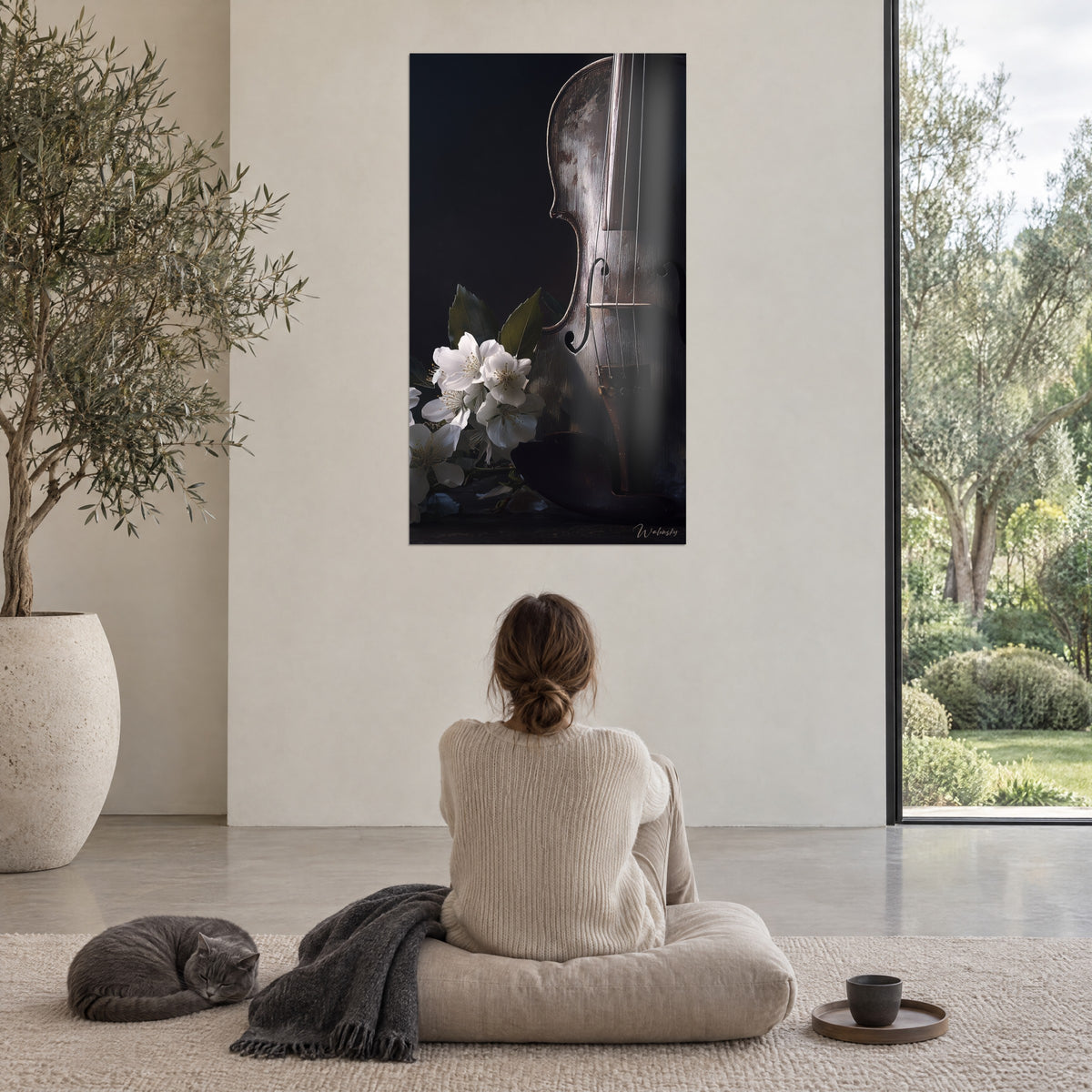 Wall art of a bow and a body in aged wood, white flowers, black shadow, young woman seen from behind on a pouf, grey shorthair cat, floor-to-ceiling window