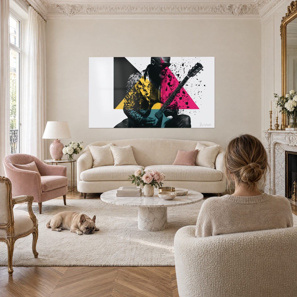 Cuadro guitarrista con chaqueta amarillo mostaza, triángulo rosa fucsia y salpicaduras negras, sobre un sofá en un salón luminoso
