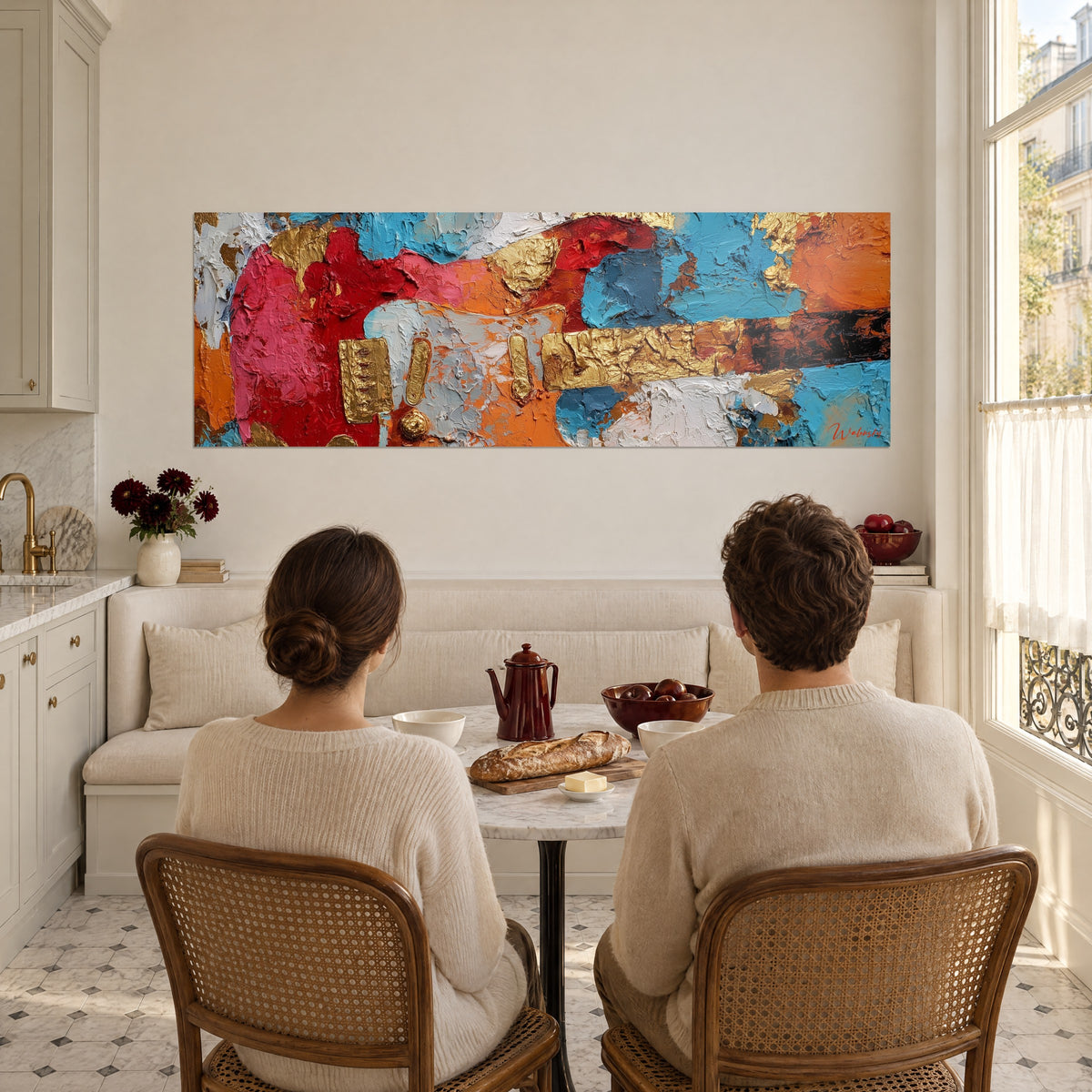 Tableau six-cordes peinte au couteau en rouge, turquoise et orange, accents dorés, face à un couple de dos attablé dans une cuisine ouverte