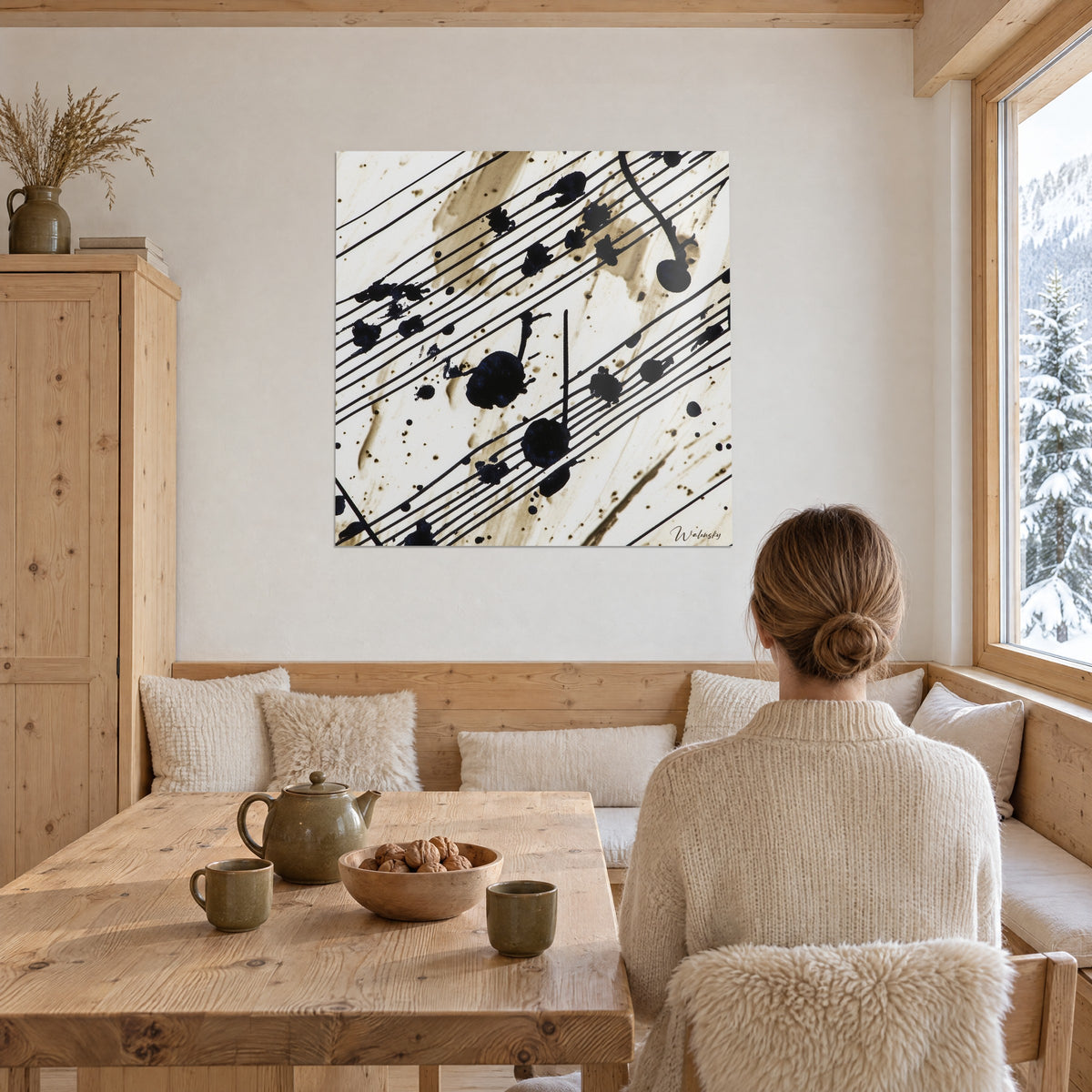 Tableau notes de musique noires aux gouttes d'encre sur fond vanille, face à une salle à manger en chalet