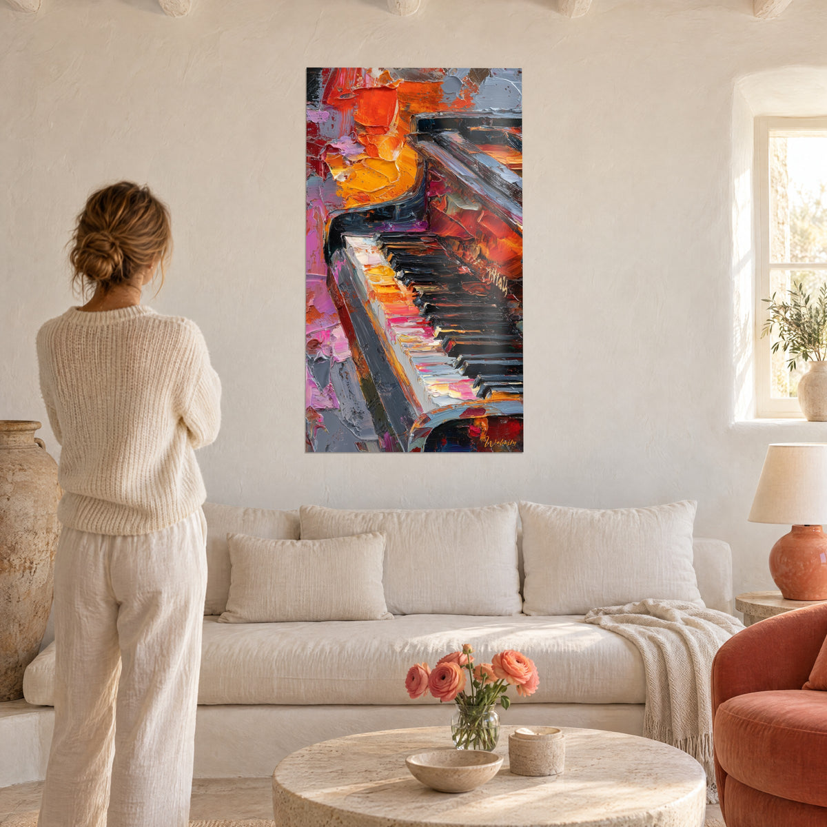 Wall art piano keyboard in thick orange and pink impasto, a woman seen from behind gazes at it above a sofa in a bright living room