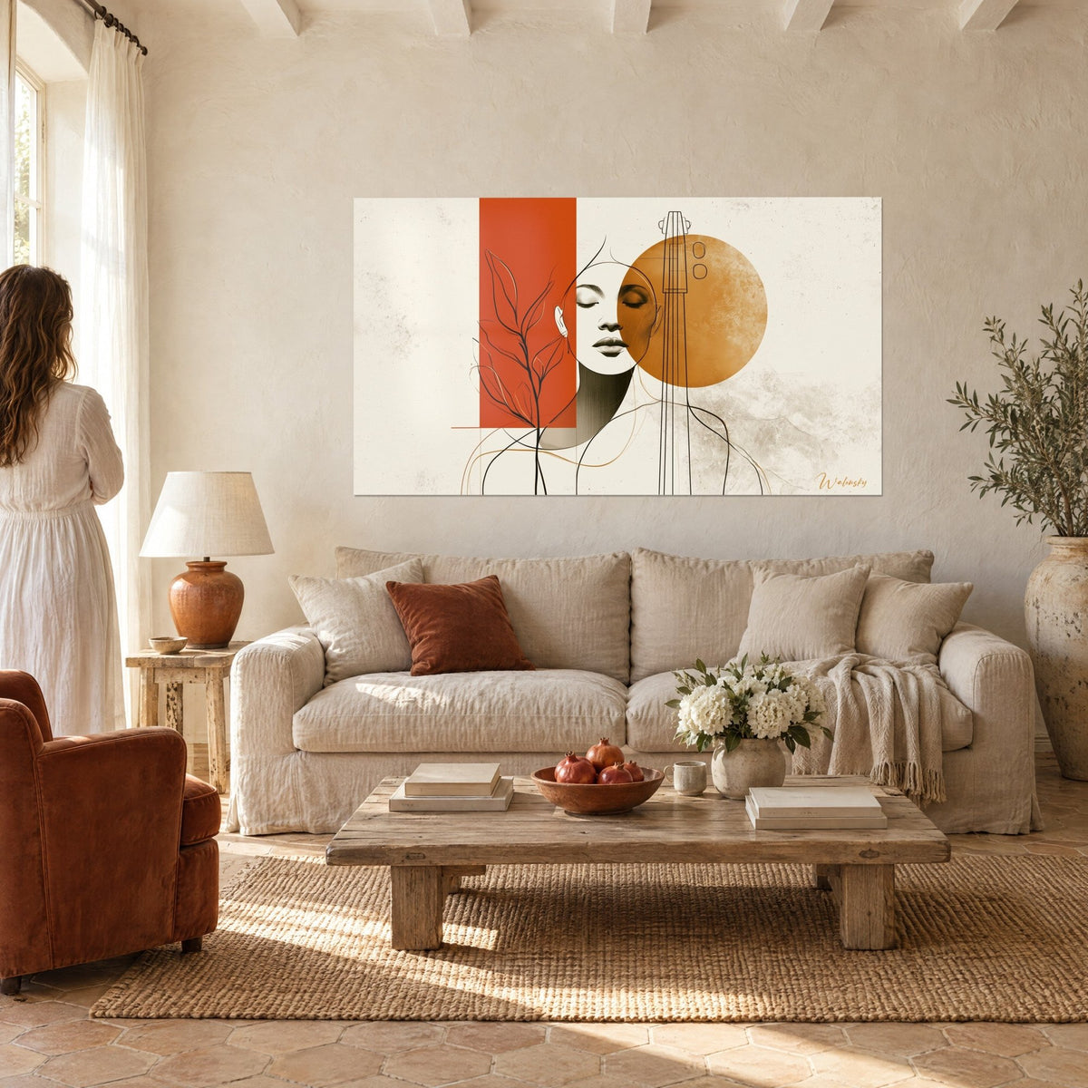 Schilderij vrouwengezicht met gesloten ogen, terracotta rechthoek en okerkleurige schijf, twee personen met hun rug boven een bank in een lichte woonkamer