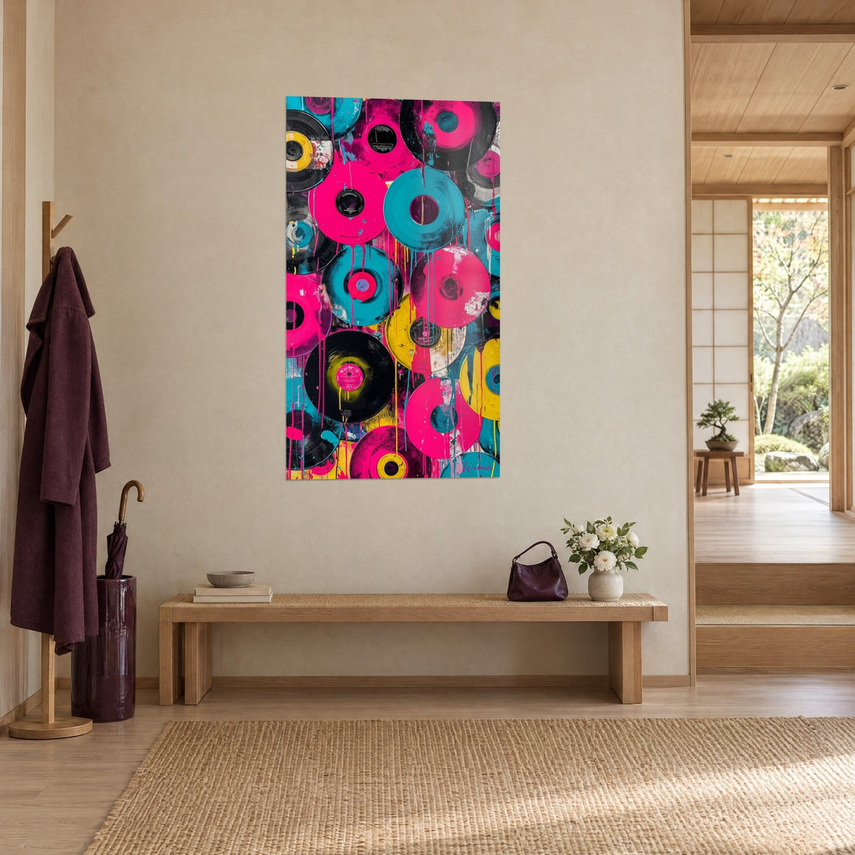 Gemälde mit schwarzer Schallplatte mit rosa Etikett und türkisfarbenen Farbläufen, an einer beigen Wand über einer Holzbank im Japandi-Stil