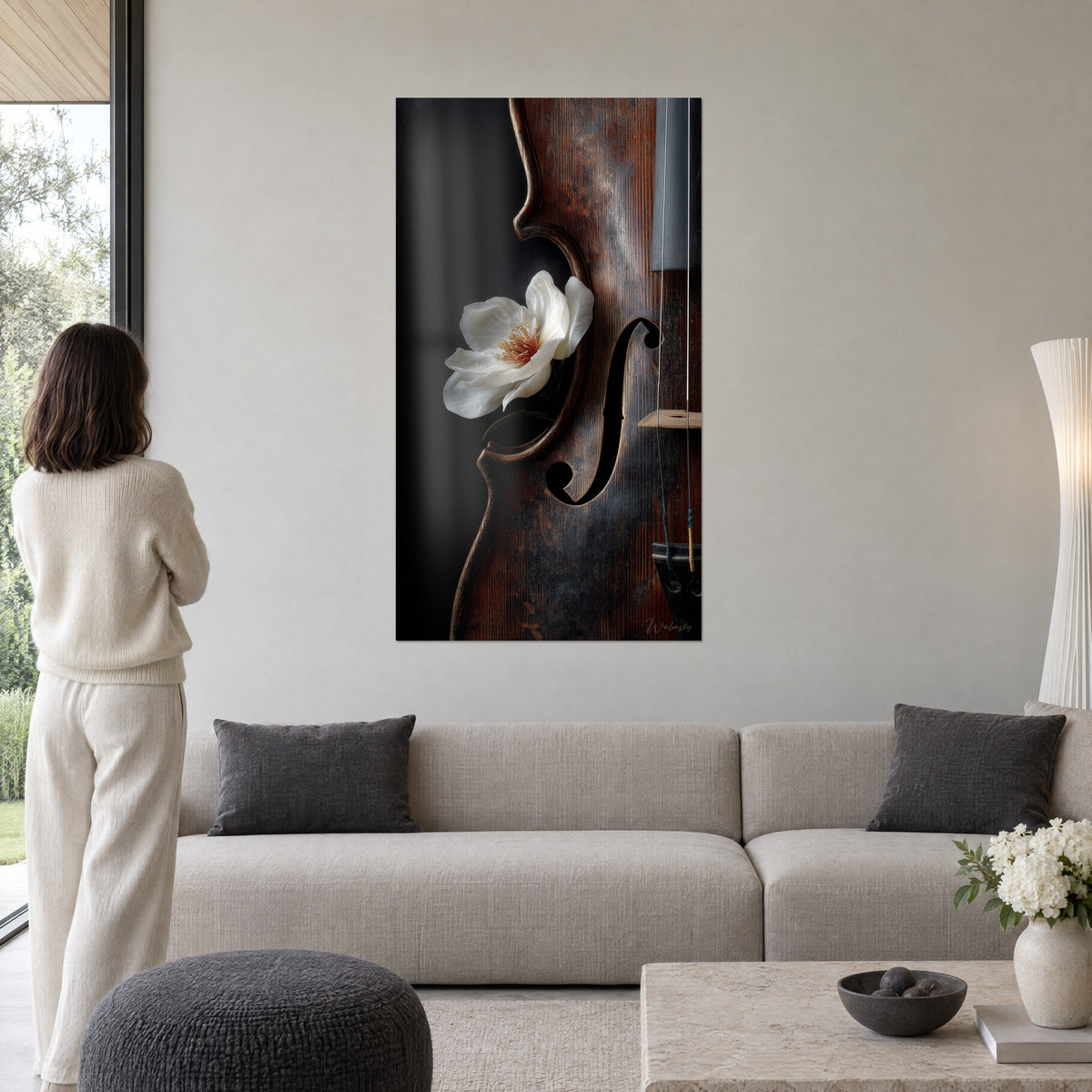 Tableau violon d'acajou et magnolia blanc, ouïe en f sur fond noir, au-dessus d'un canapé dans un salon lumineux