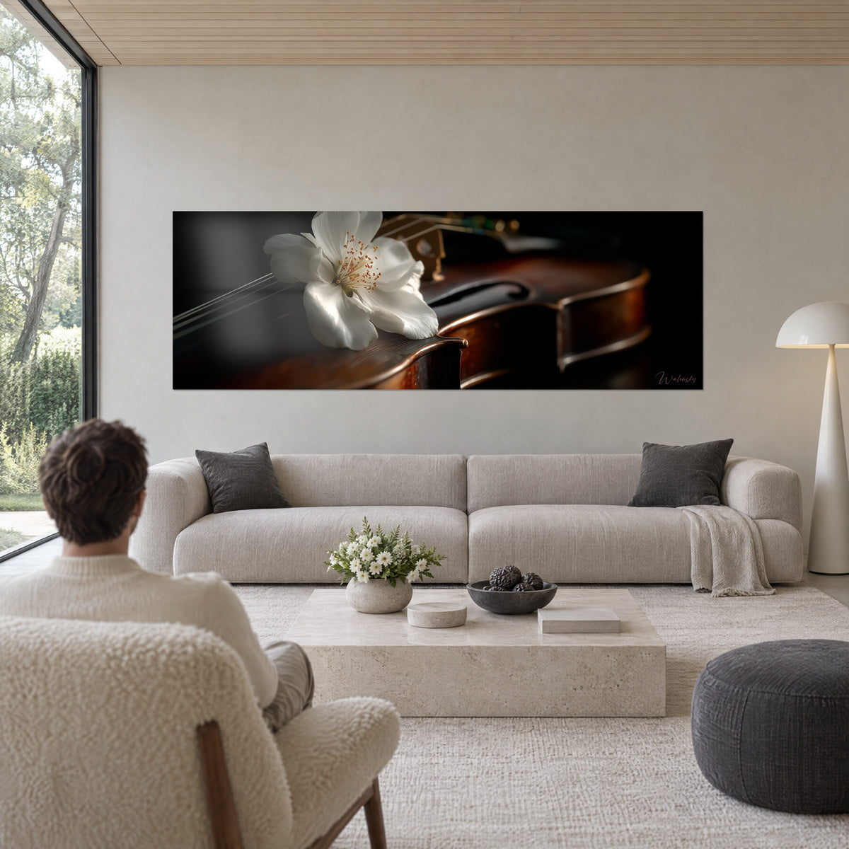 Tableau grande corolle blanche posée sur un violon brun ambré, étamines dorées, fond noir, au-dessus d'un canapé dans un salon lumineux