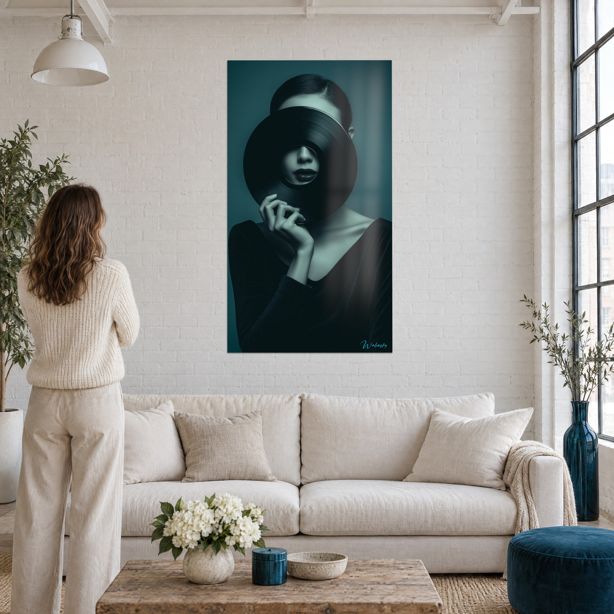 Quadro donna con un disco in vinile nero sul viso, sfondo blu petrolio, donna di spalle, sopra un divano in un soggiorno luminoso